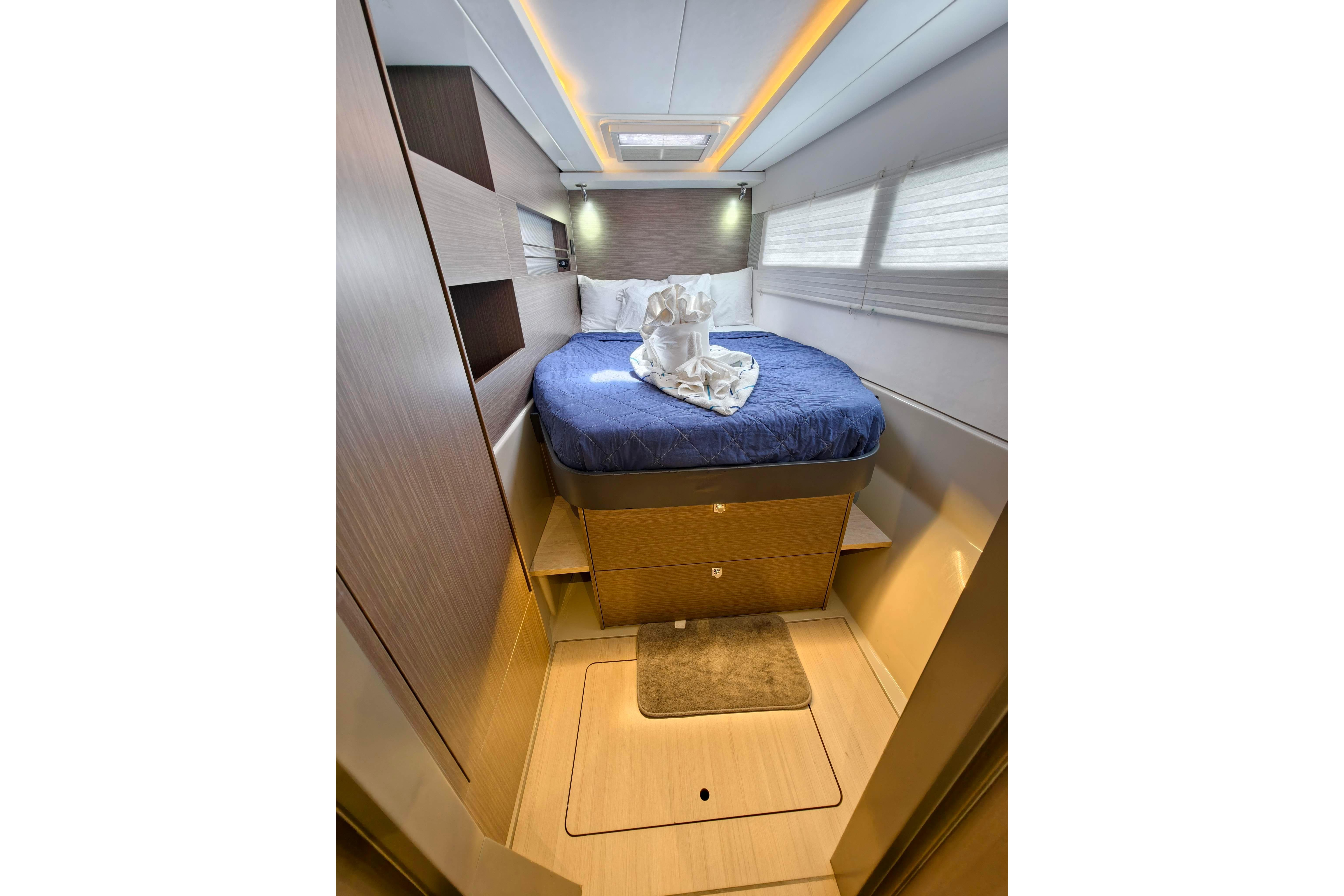 Luxurious cabin interior of 2022 Leopard 45 yacht with cozy bed and elegant lighting.