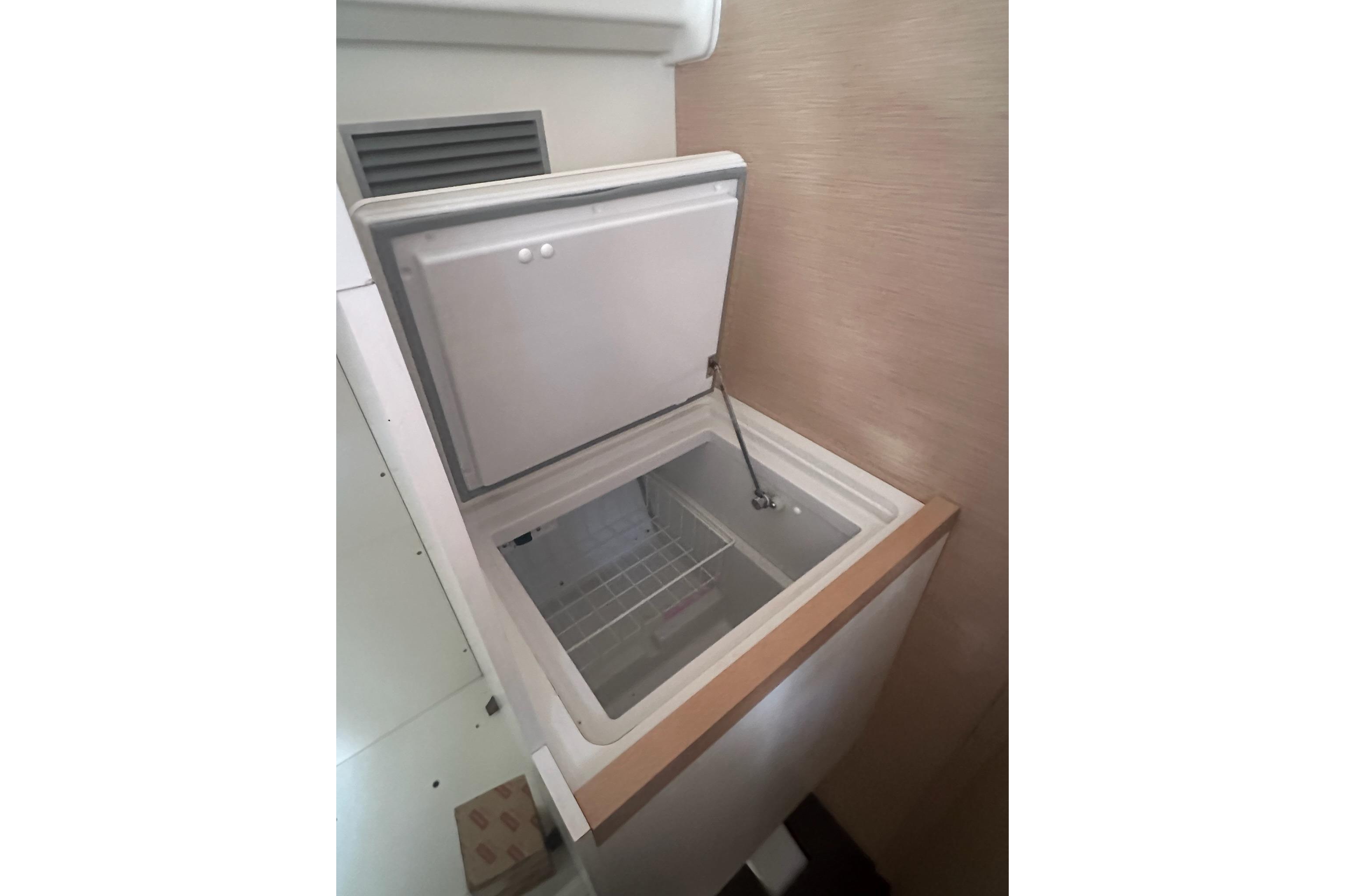 Open freezer compartment in 2018 Jeanneau 51 yacht, showcasing interior storage space.