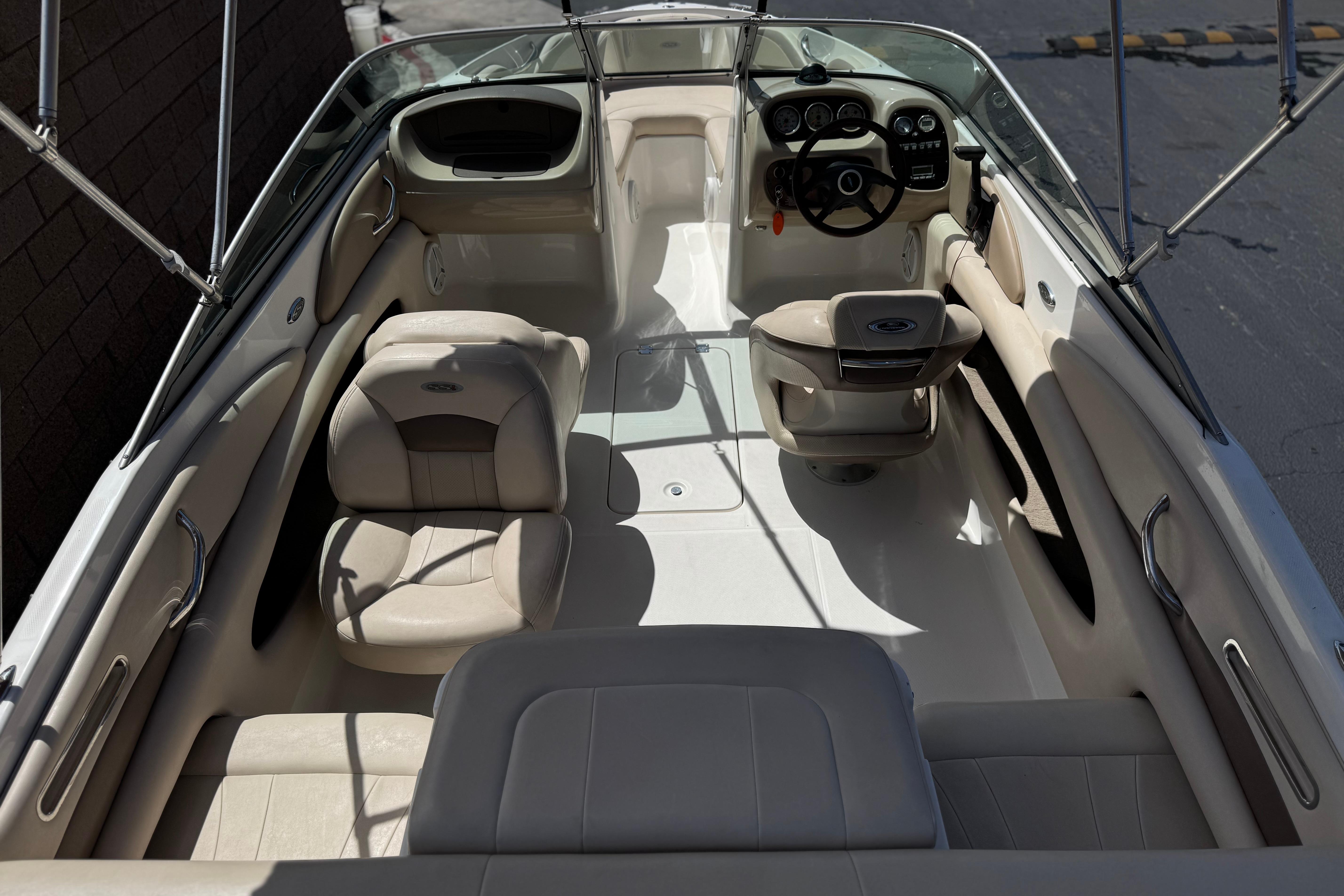Interior view of a 2006 Chaparral 190 SSi boat, featuring beige seating and steering console.