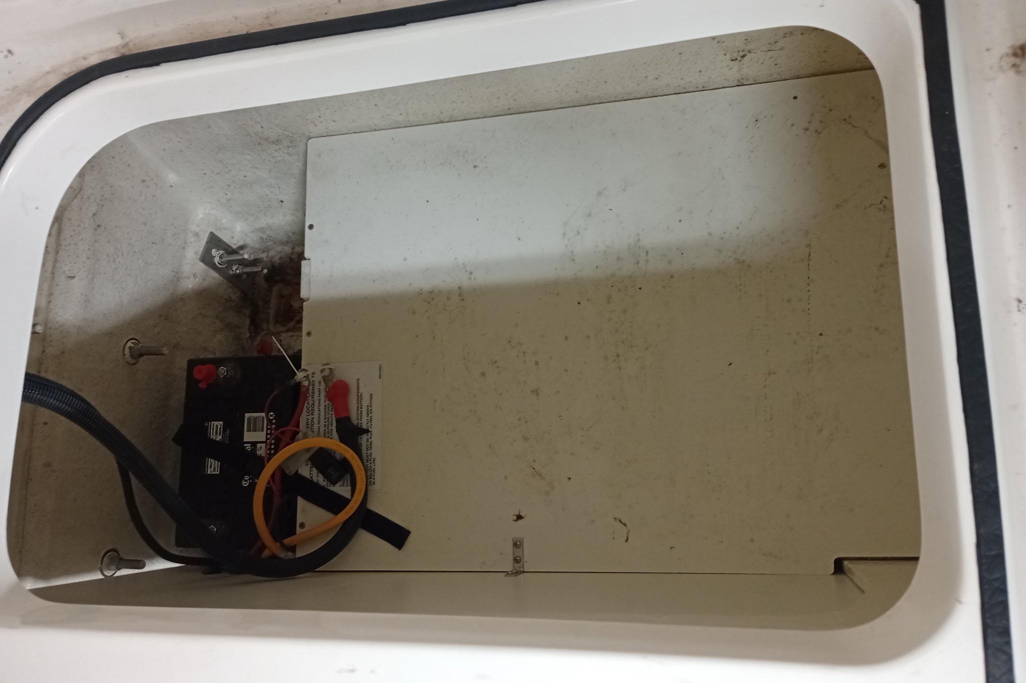 2022 Bayliner VR5 Bowrider I/O battery compartment, featuring a secured battery and wiring.