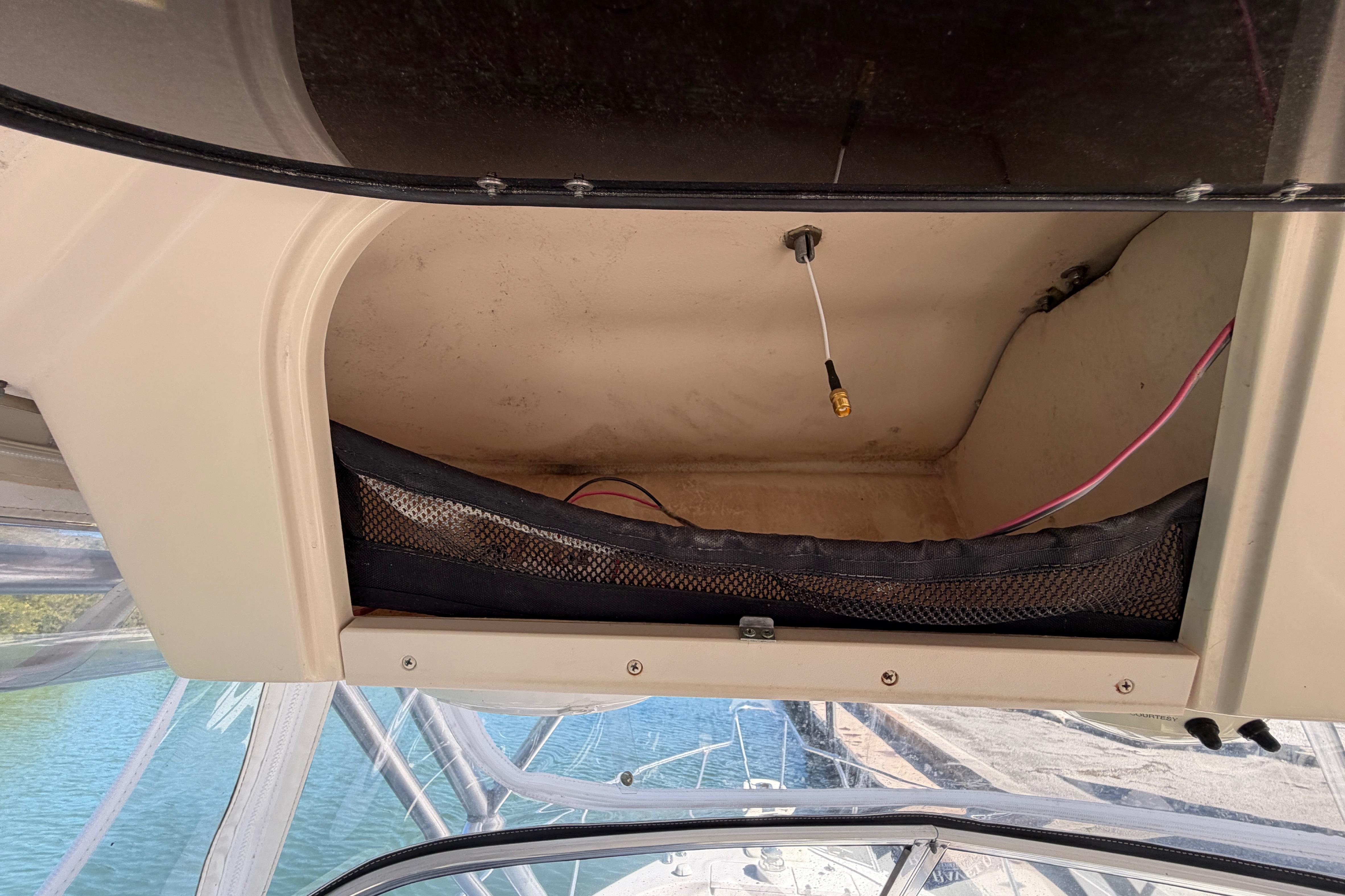 Storage compartment on a 2006 Grady-White Sailfish 282 boat, featuring wiring and mesh netting.