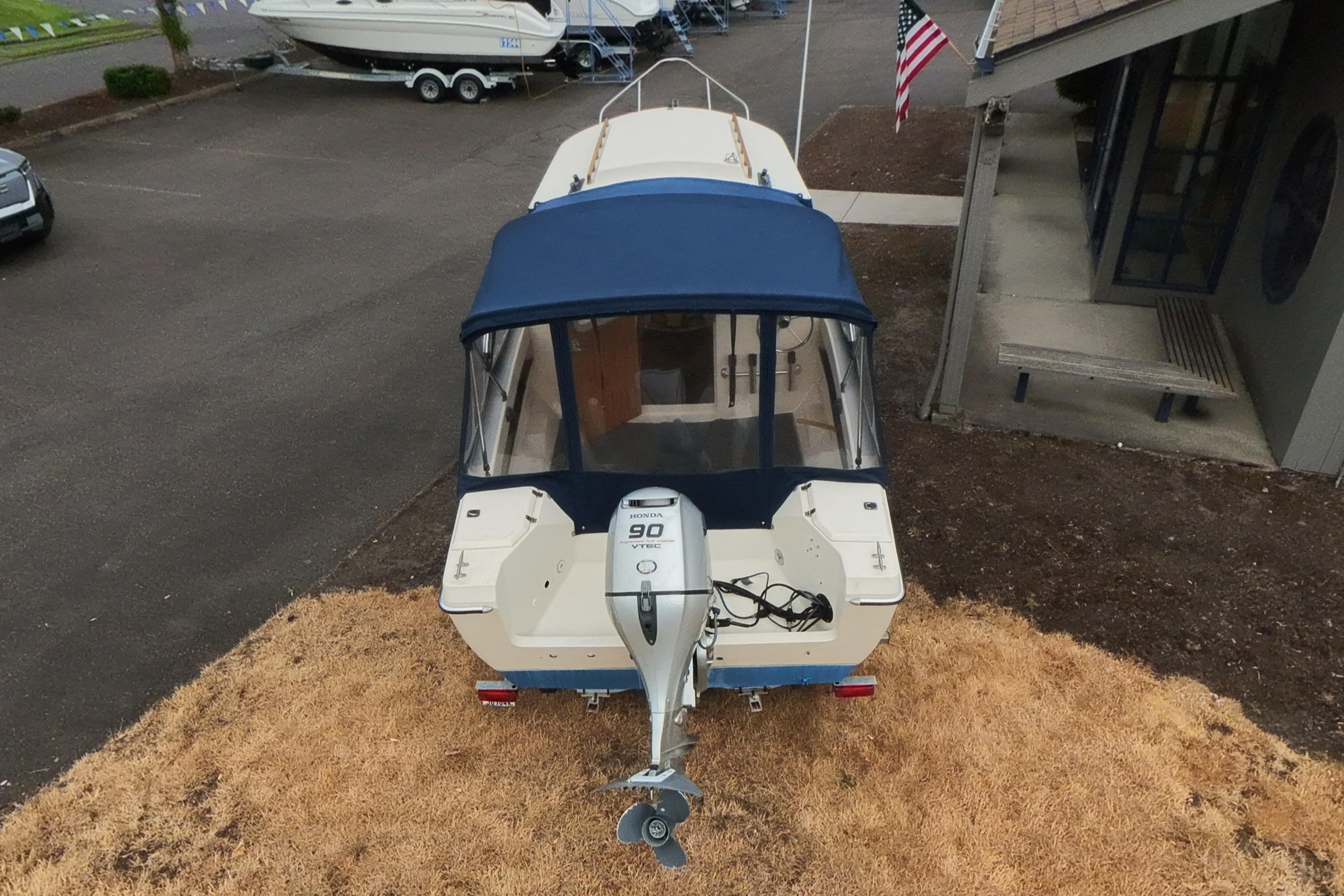 1989 C-Dory 22' Angler boat with Honda 90 VTEC engine, parked outdoors.