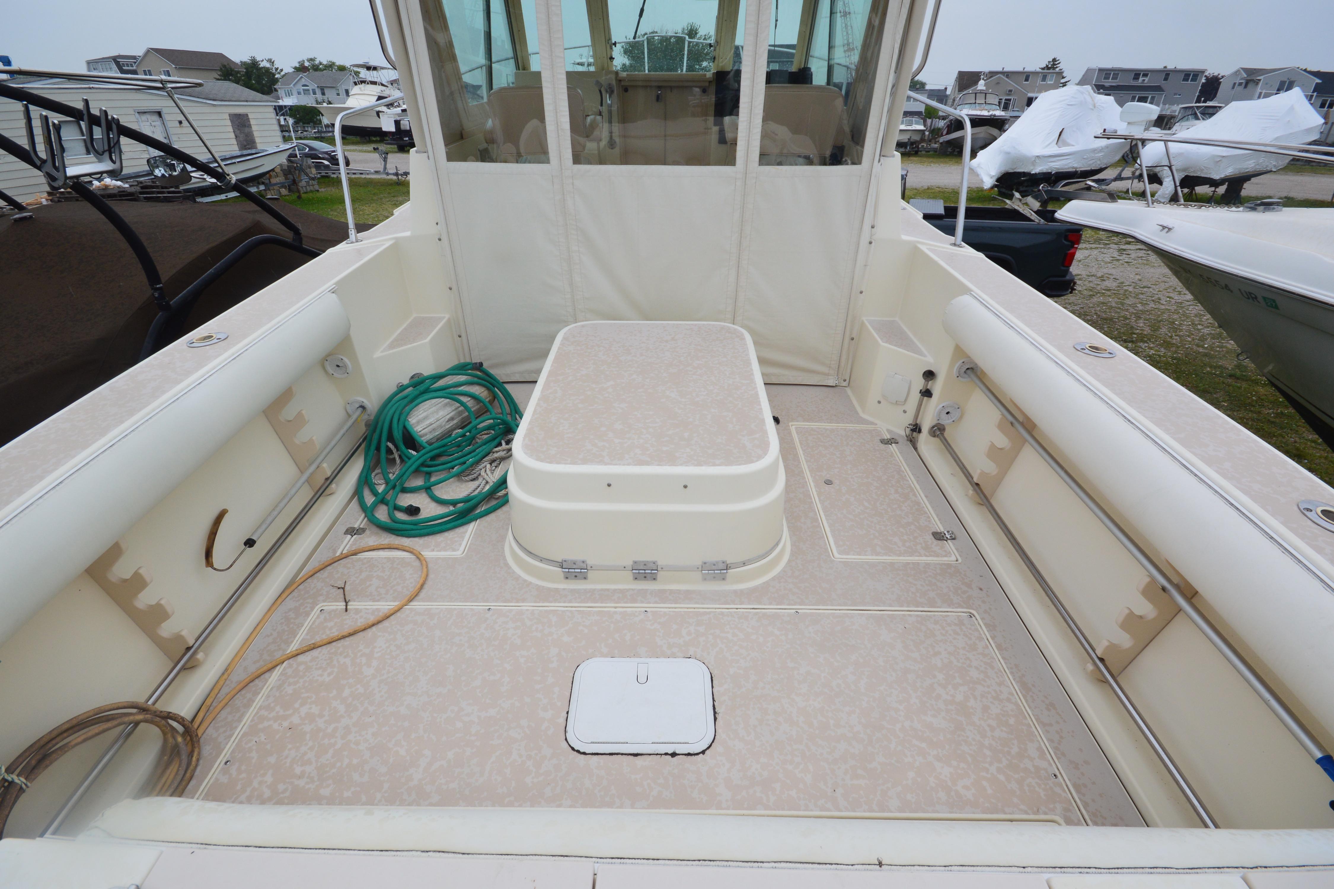 2001 Albin 28 Tournament Express boat deck with storage and coiled hose.