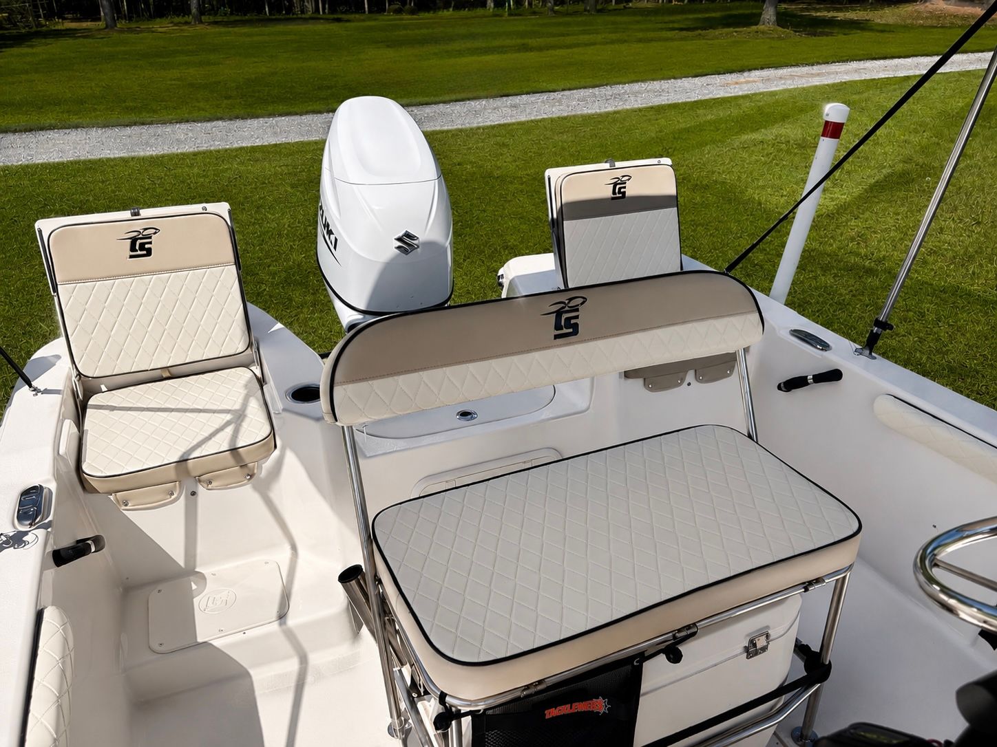 Interior view of a Carolina Skiff 17 LS boat with cushioned seats and a Suzuki outboard motor.