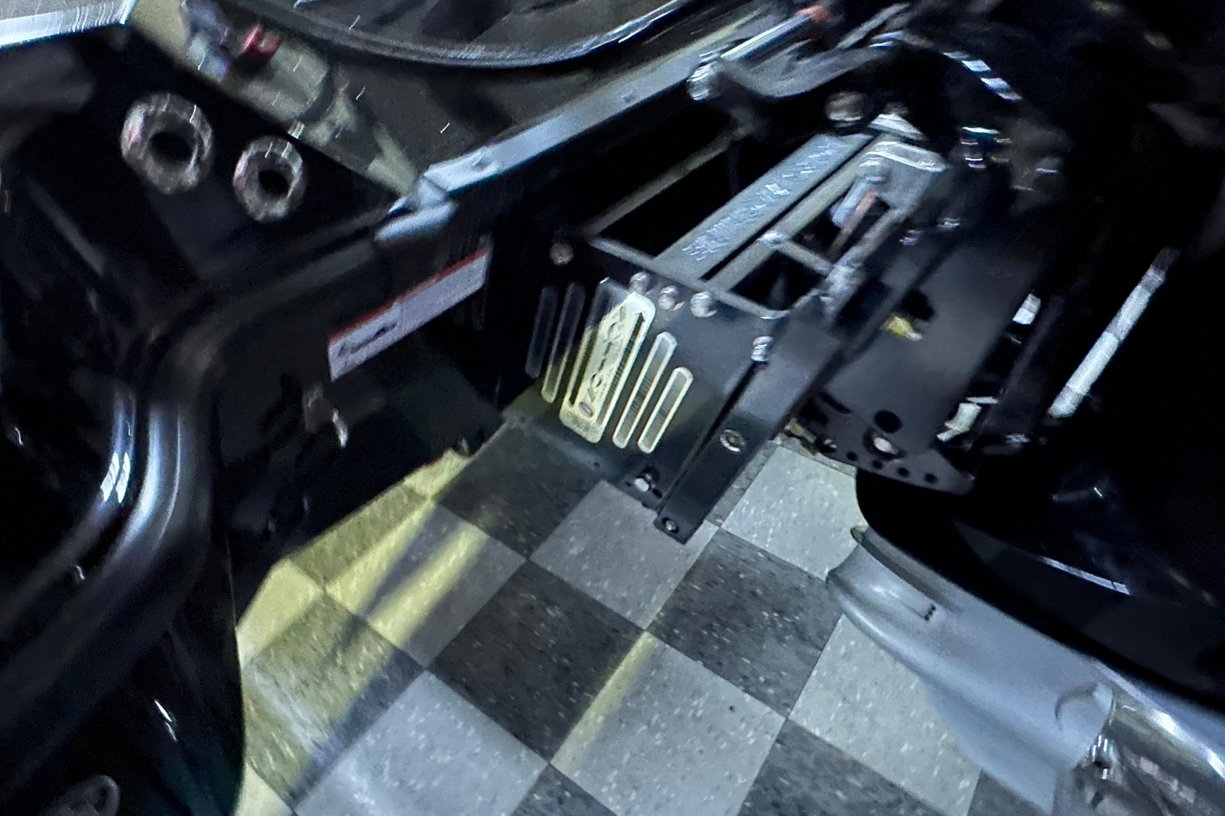 Close-up of 2025 Triton 21XP Patriot boat engine mount on checkered floor.