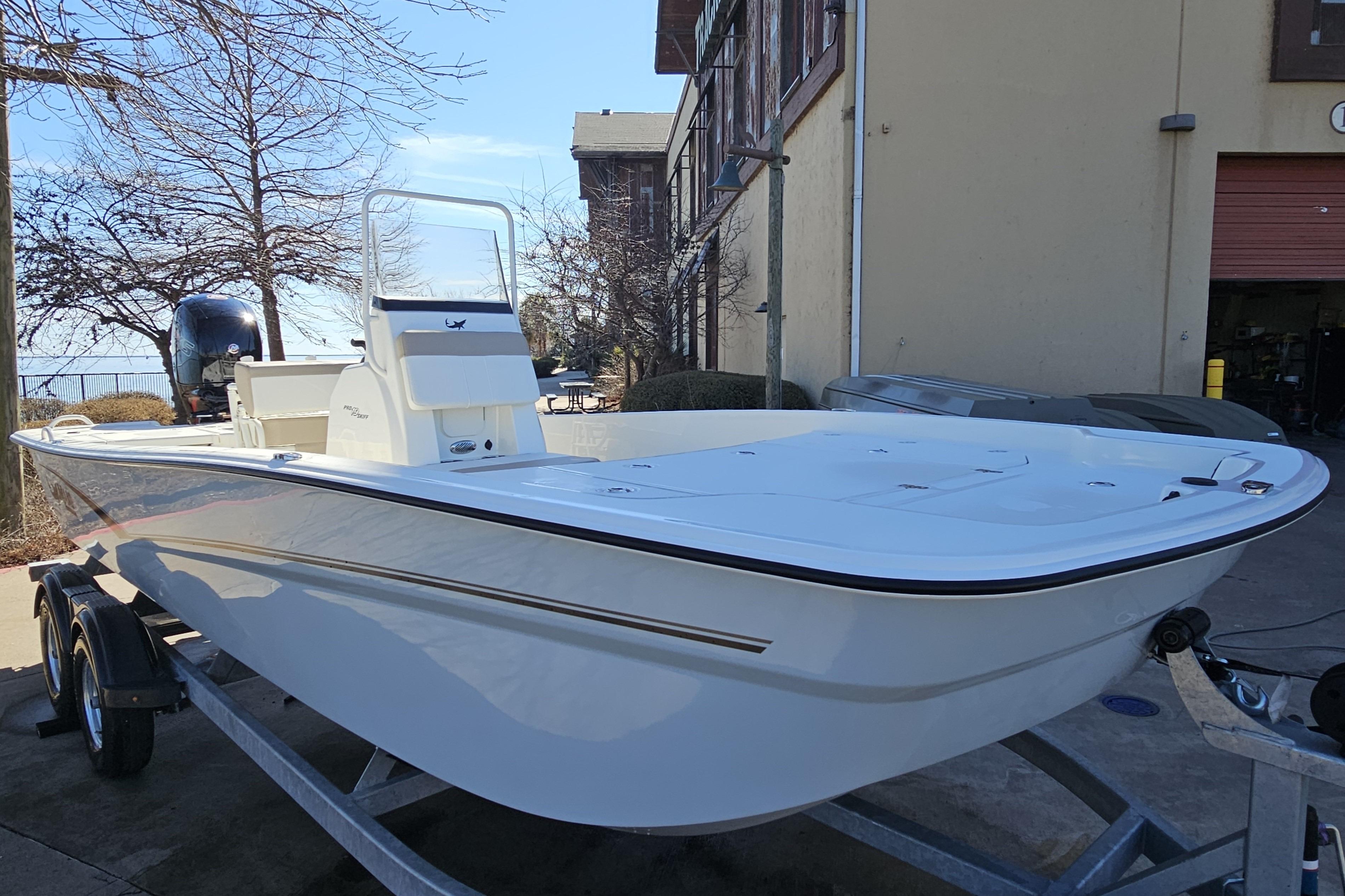 2026 Mako Pro Skiff 19 CC boat on trailer, parked outdoors near building.