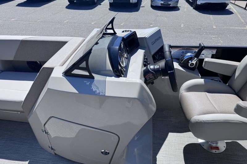 2027 Manitou Aurora 23 RF SHP boat interior with steering console and seating.