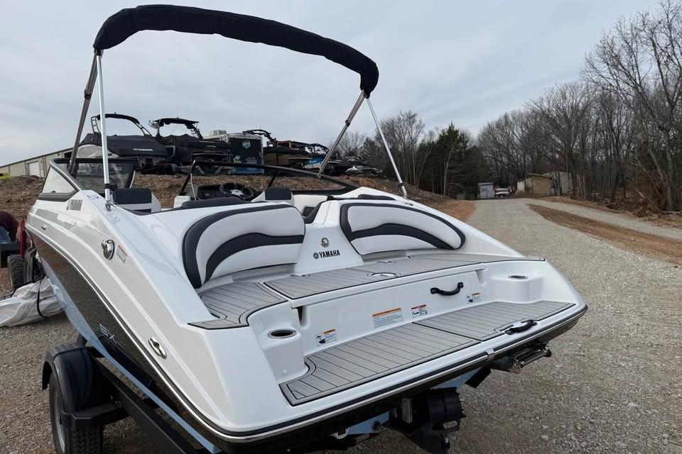 2026 Yamaha Boats SX195, sleek white design, parked on a gravel path.