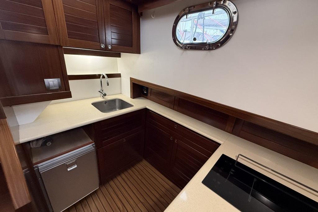 Luxurious kitchen interior of 2012 Sasga Yachts Menorquin 42 with wooden cabinetry and modern appliances.