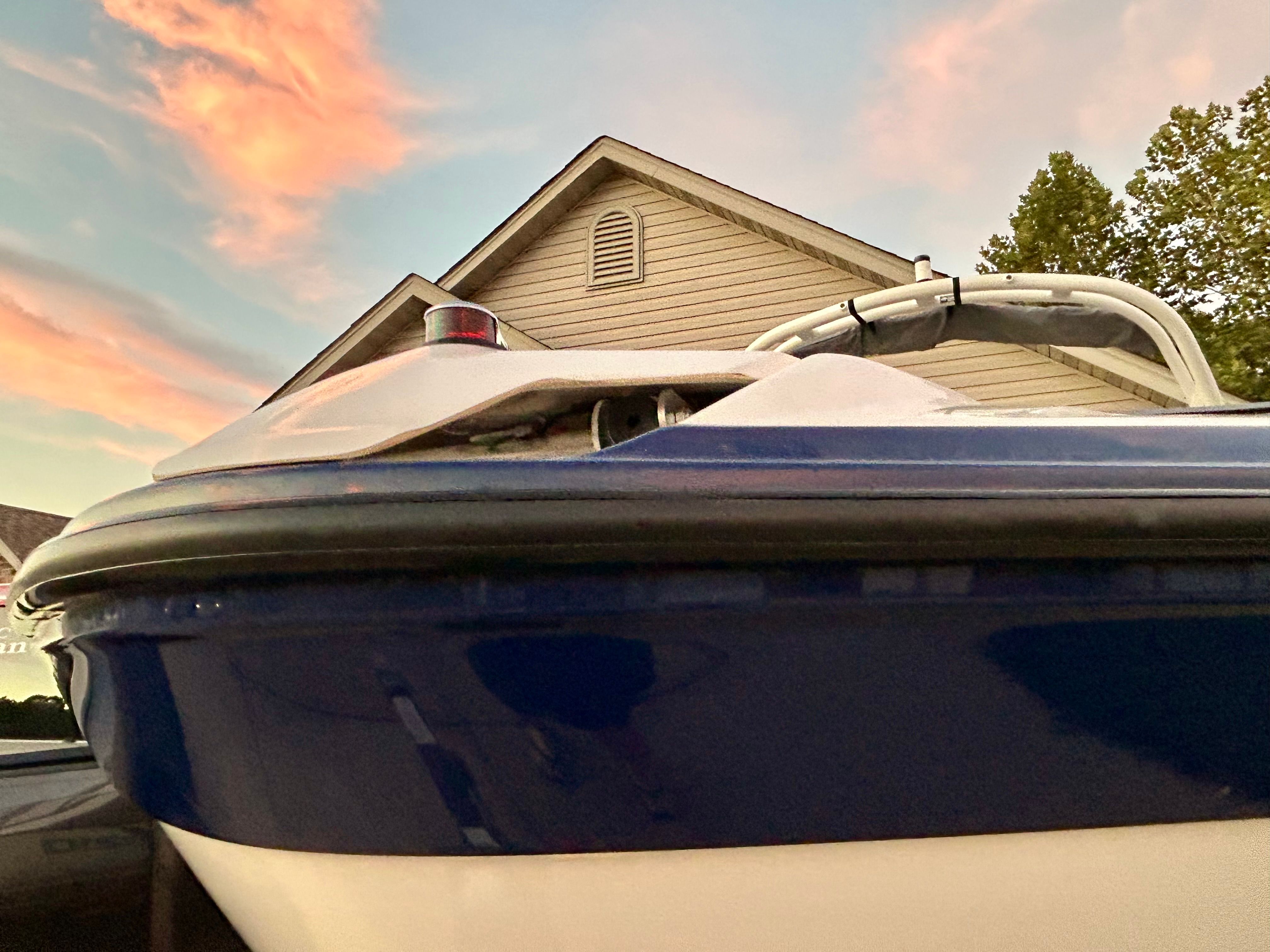 A Yamaha AR210 boat in front of a house at sunset.