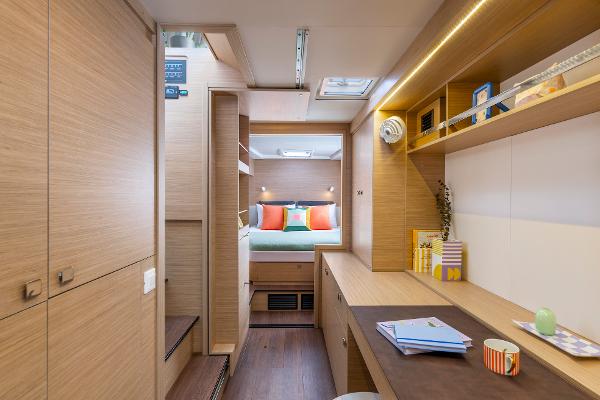 Interior of 2025 Lagoon 43 yacht, featuring modern wood finishes and cozy bedroom.