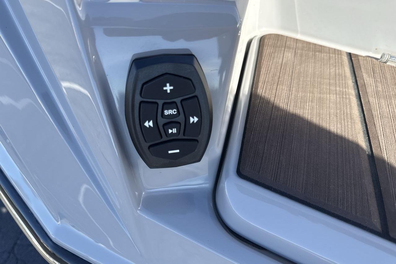 Control panel on 2024 Supra SV boat with audio buttons and wooden deck.