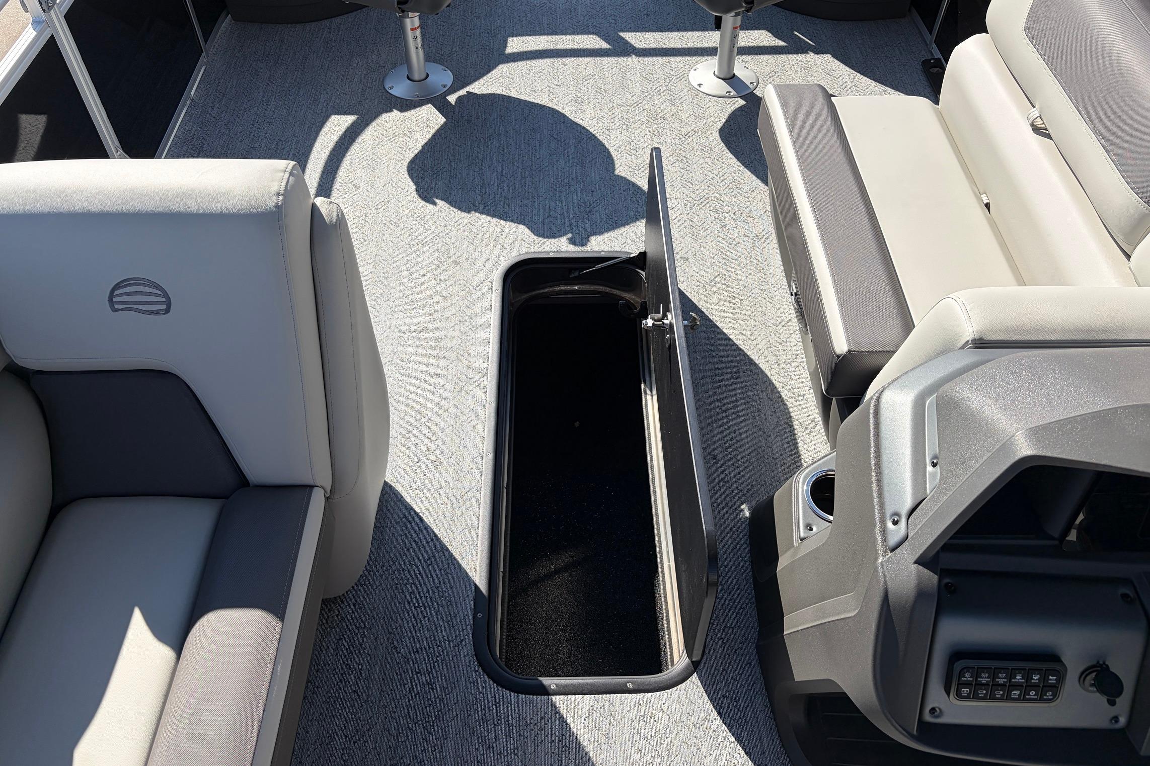 Interior view of 2026 Sun Tracker Fishin' Barge 22 XP3 with open storage compartment.