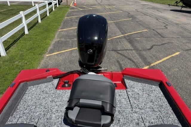 2026 Tracker Pro Team 175 boat with red trim and outboard motor in parking lot.
