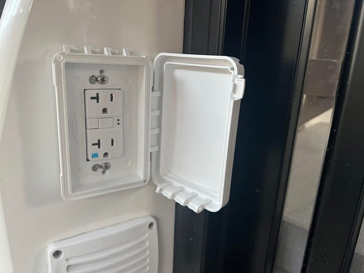 An electrical outlet with a protective cover on a 2019 Jeanneau NC 895 boat.