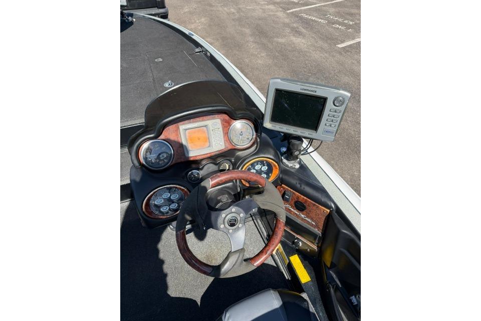 2005 Triton Tr-21X PD boat dashboard with steering wheel and navigation system.