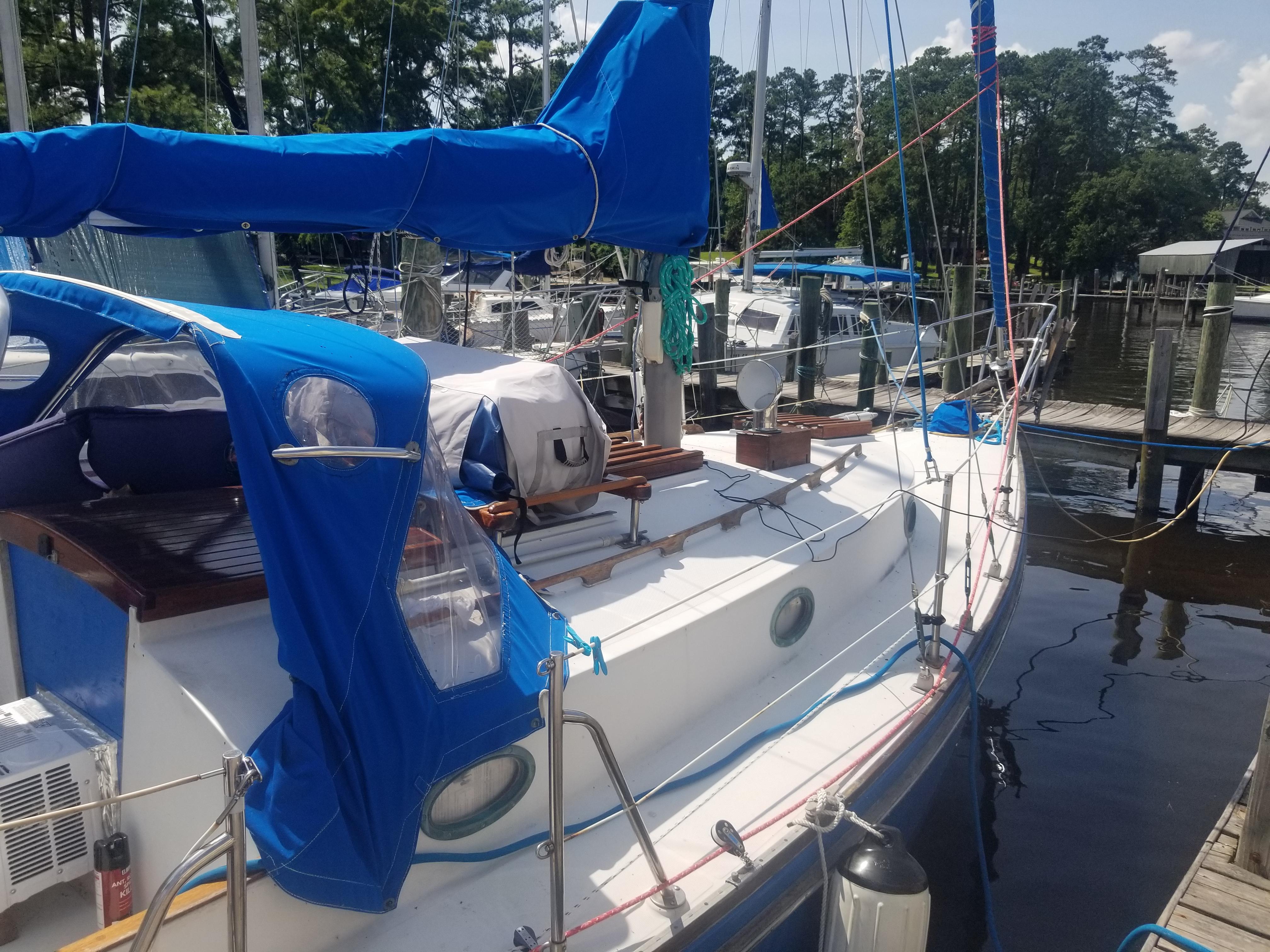 1977 Ericson 31 sailboat docked with blue cover.