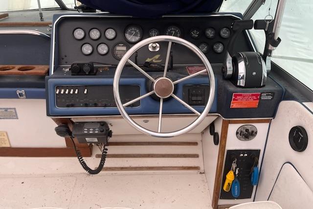 1989 Sea Ray 300 Sundancer helm with steering wheel, gauges, and control panel.