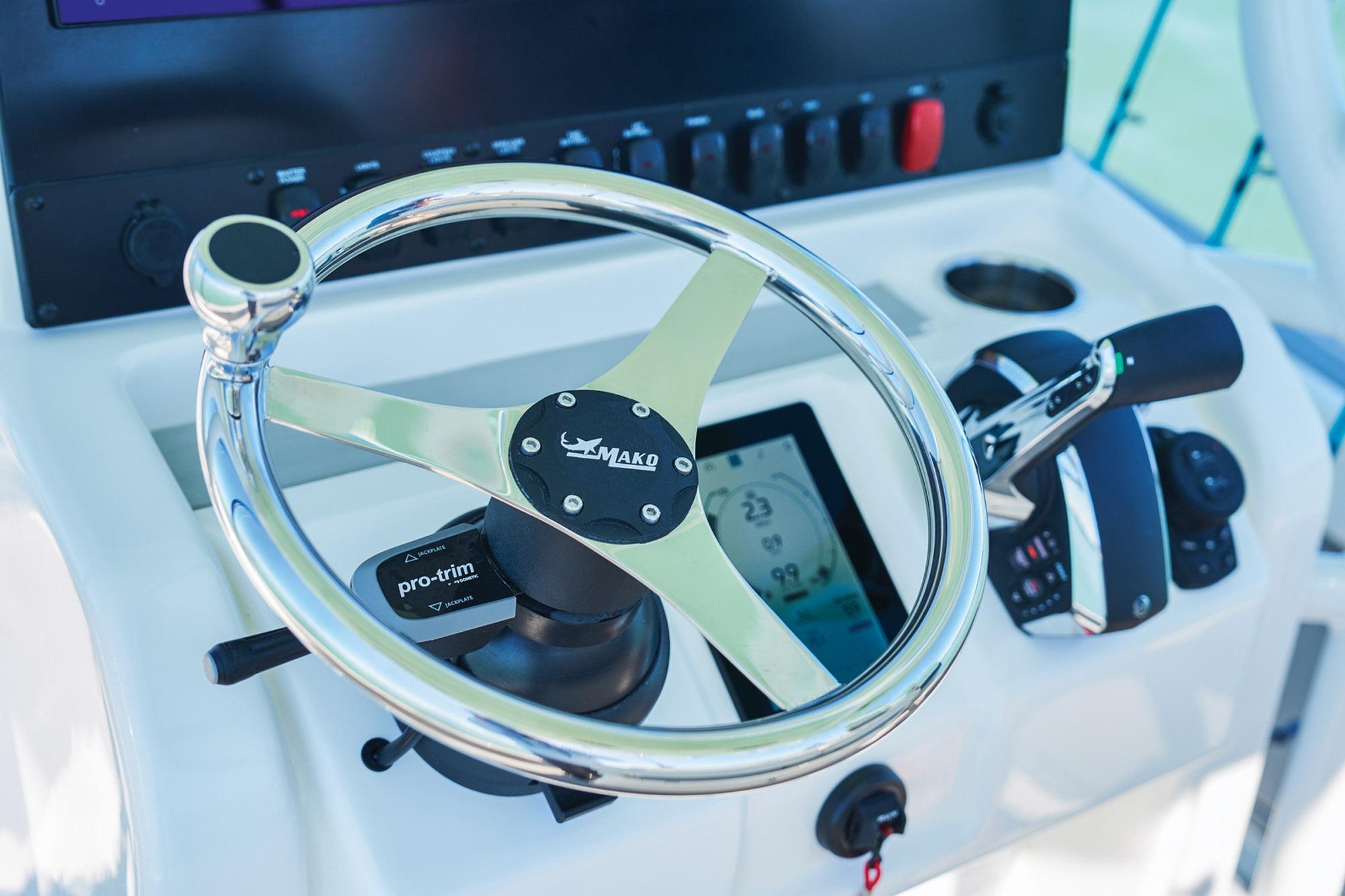 Steering console of 2026 Mako 24 APEX boat with chrome wheel and controls.