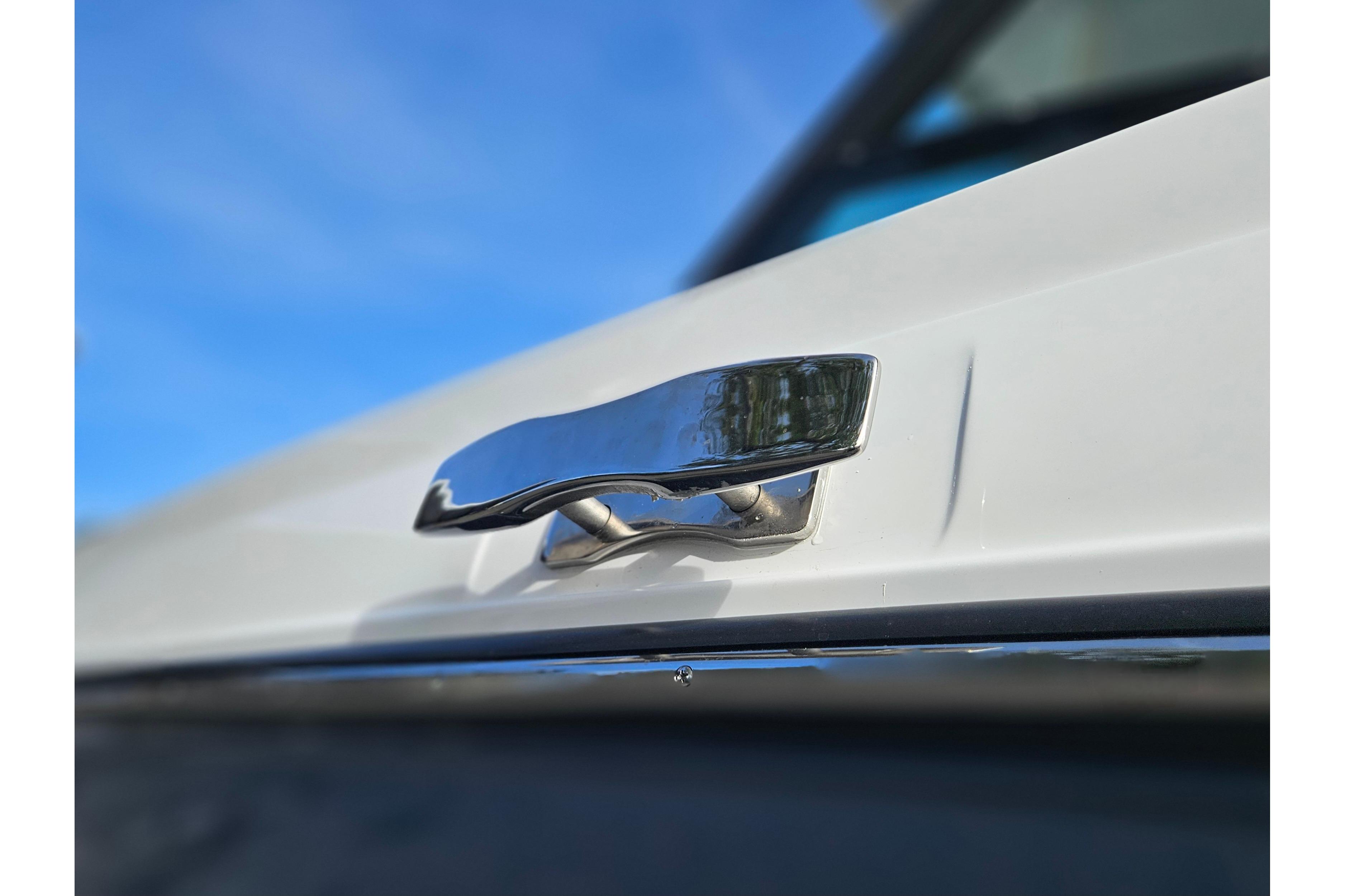 Sleek chrome handle on 2026 Monterey Elite 27 OB boat against blue sky.