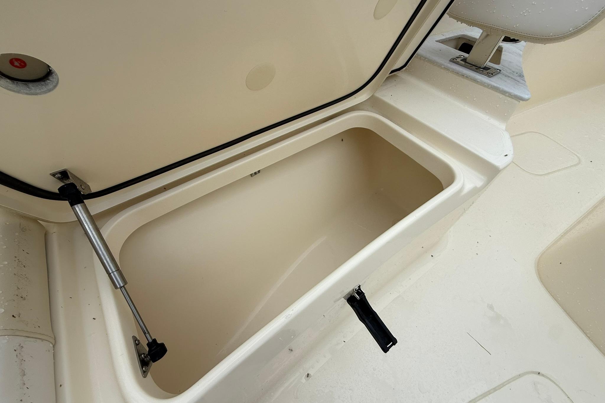 Open storage compartment on 2026 Scout 260 LXF boat, showcasing interior space.