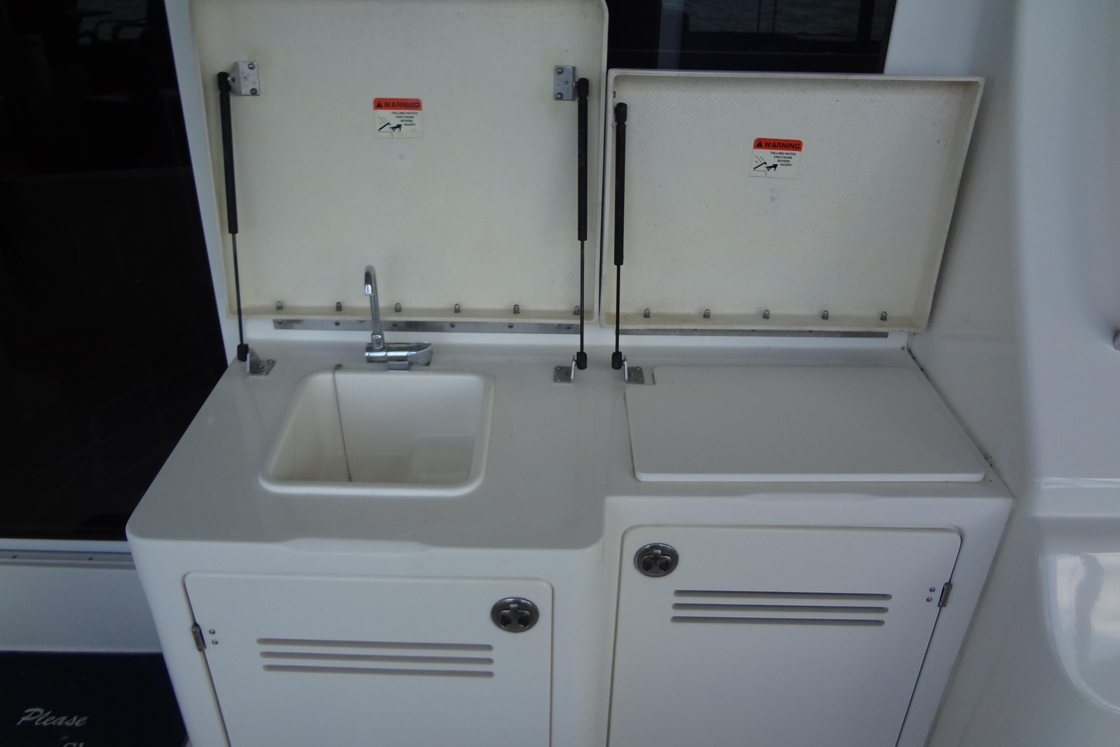 2005 Silverton 34 Convertible yacht sink and storage area with open lids.