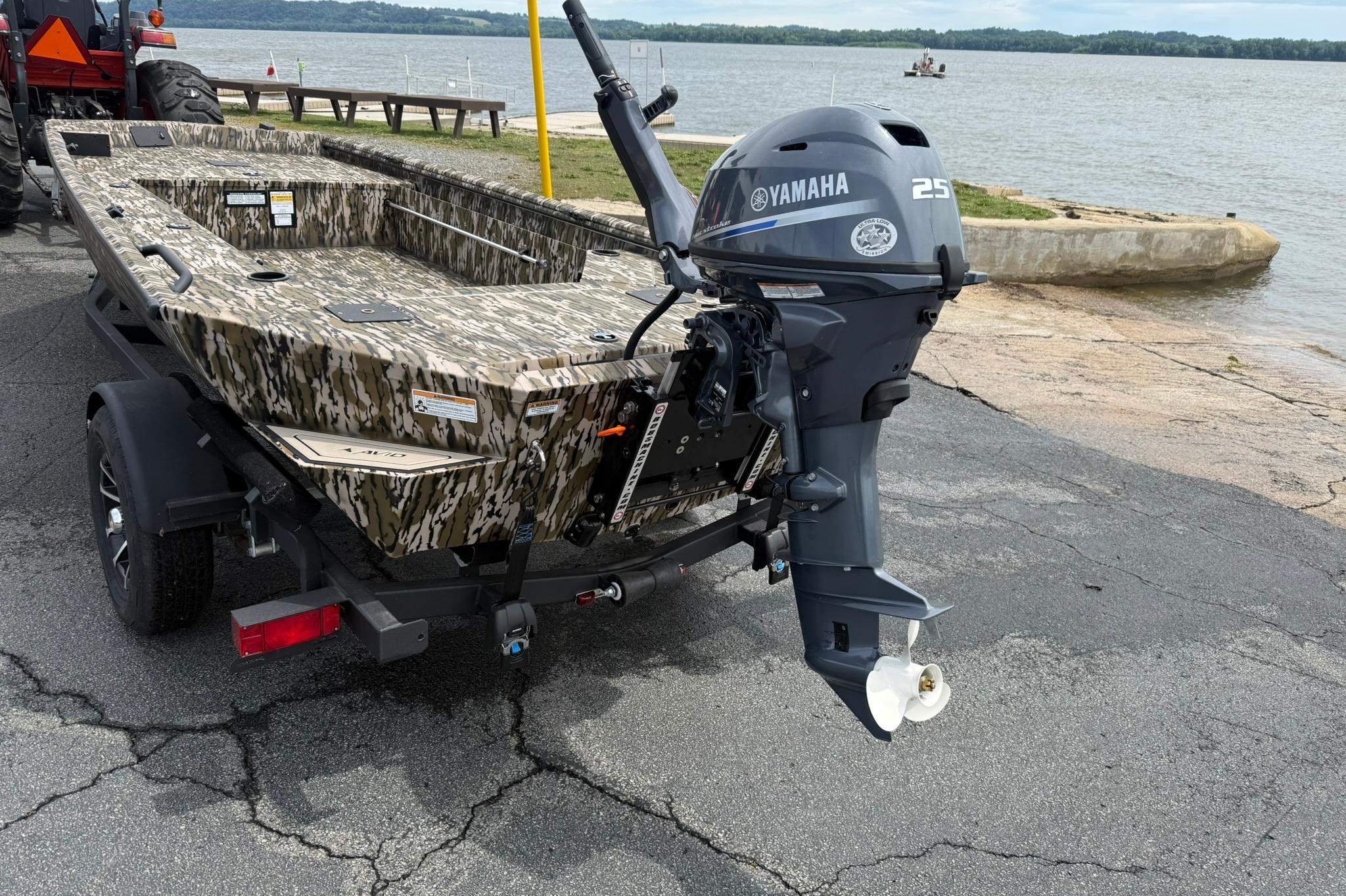 2026 Avid 16 Commander boat with Yamaha 25 engine by a lakeside.