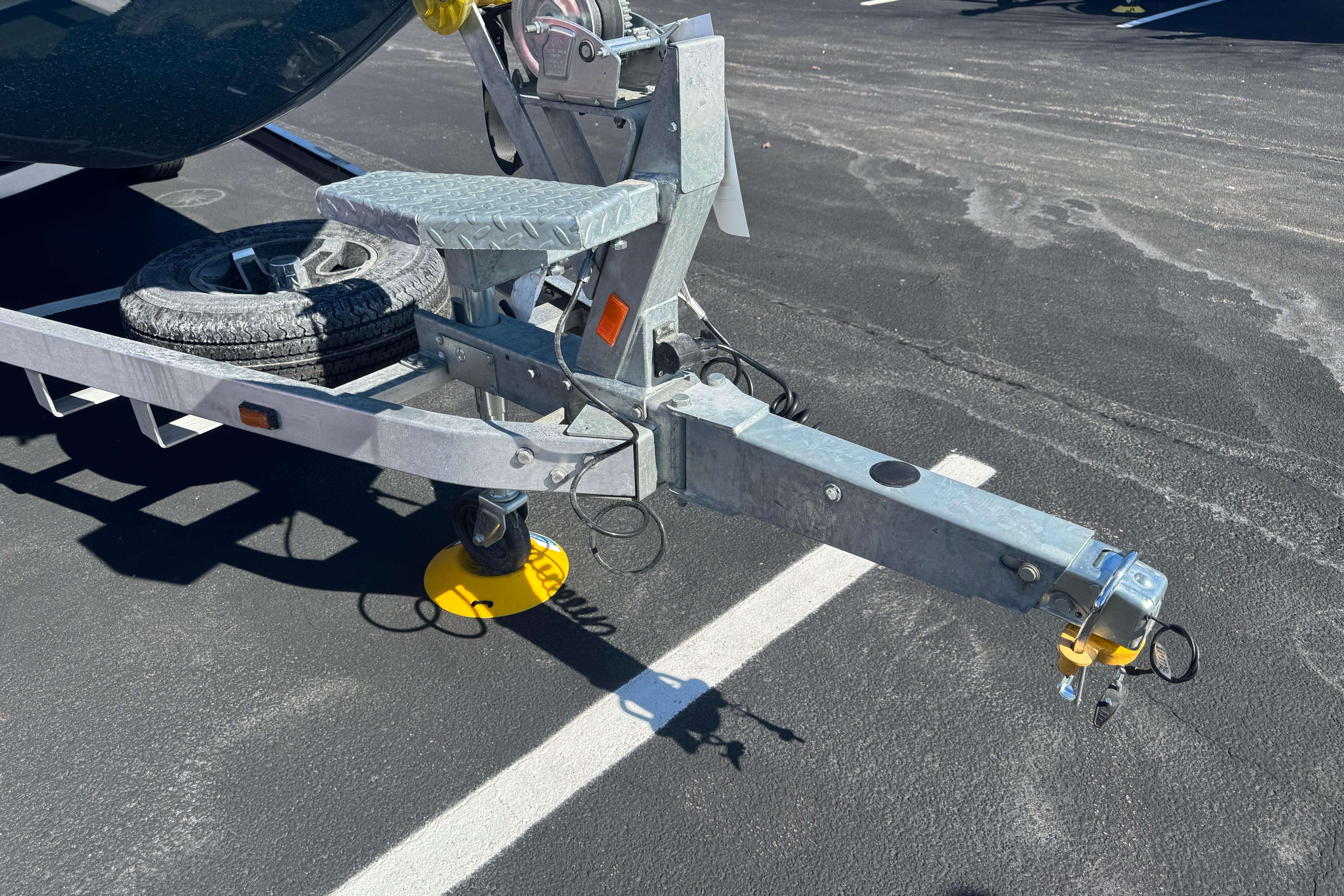 Trailer hitch of 2026 Ranger RB200 boat with spare tire on asphalt.
