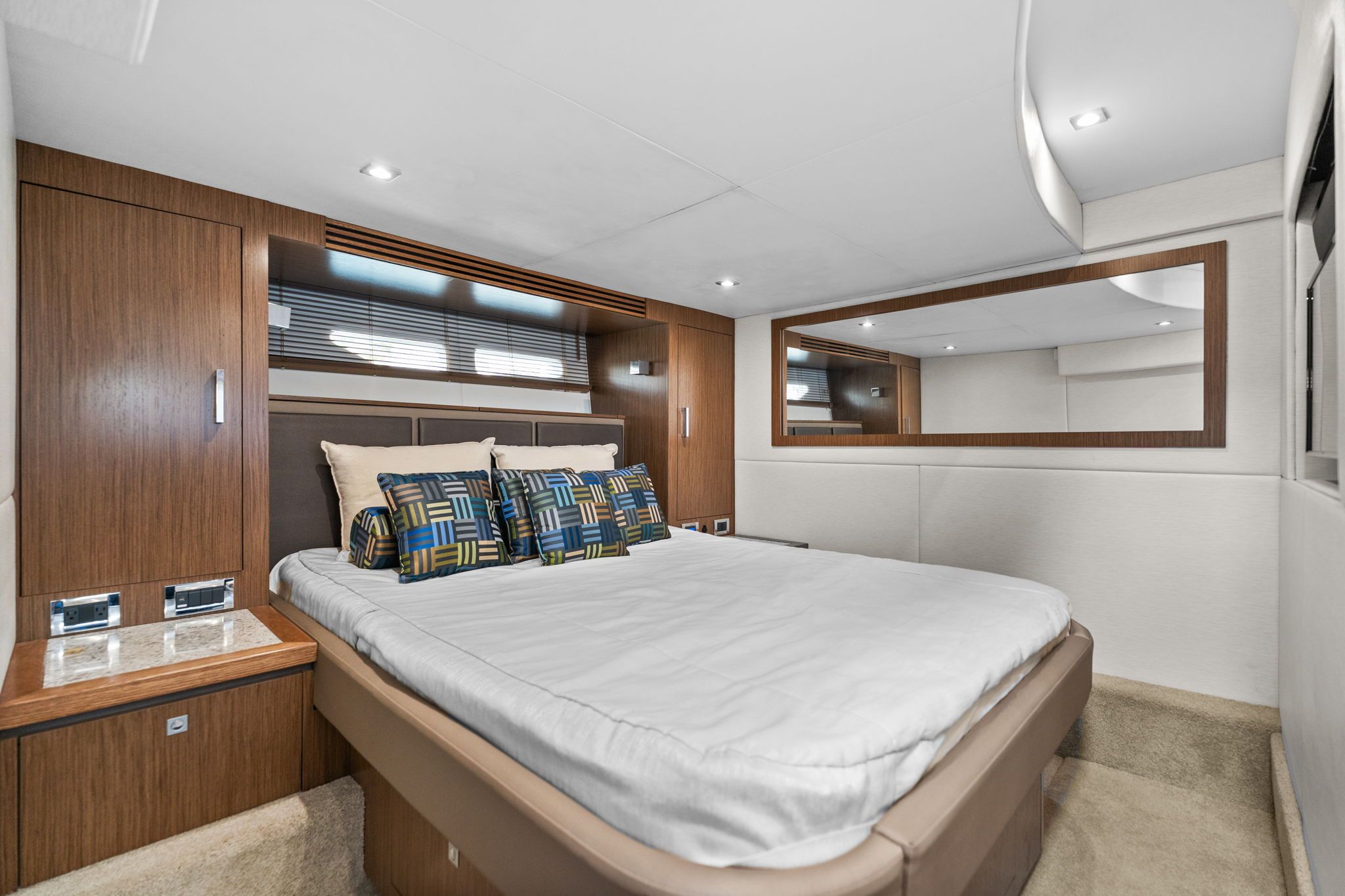 Luxurious bedroom with modern design, wood accents, and large mirrors.