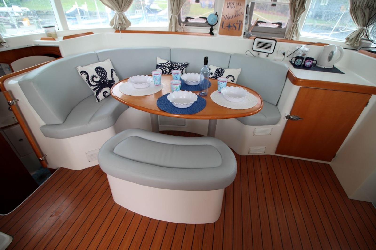 Cozy dining area in a 2004 Lagoon 380 catamaran with elegant seating and decor.