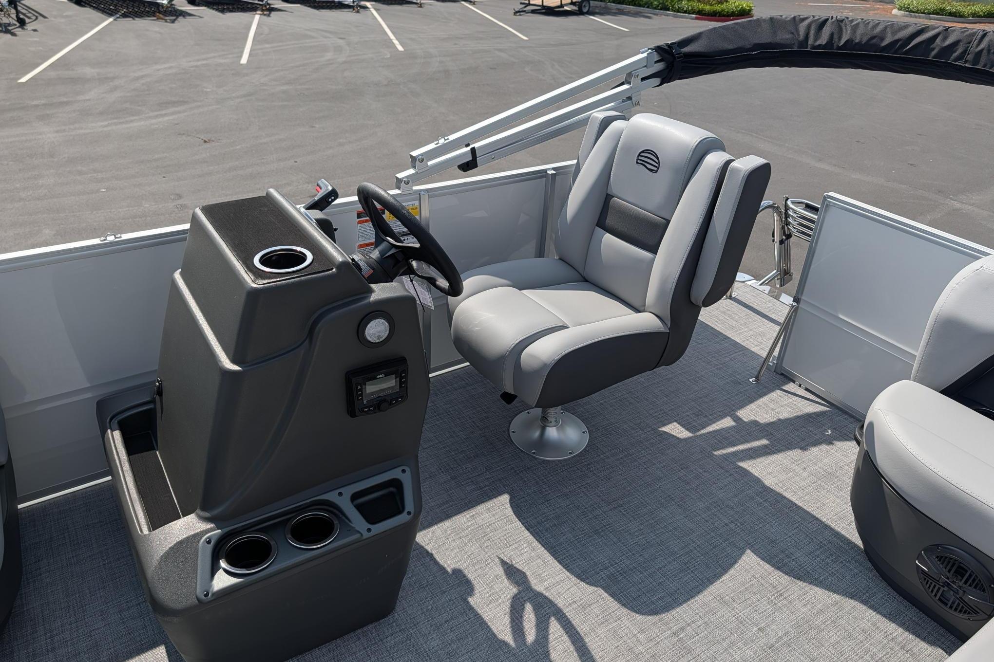 2026 Sun Tracker Party Barge 16 DLX interior with captain's chair and steering console.