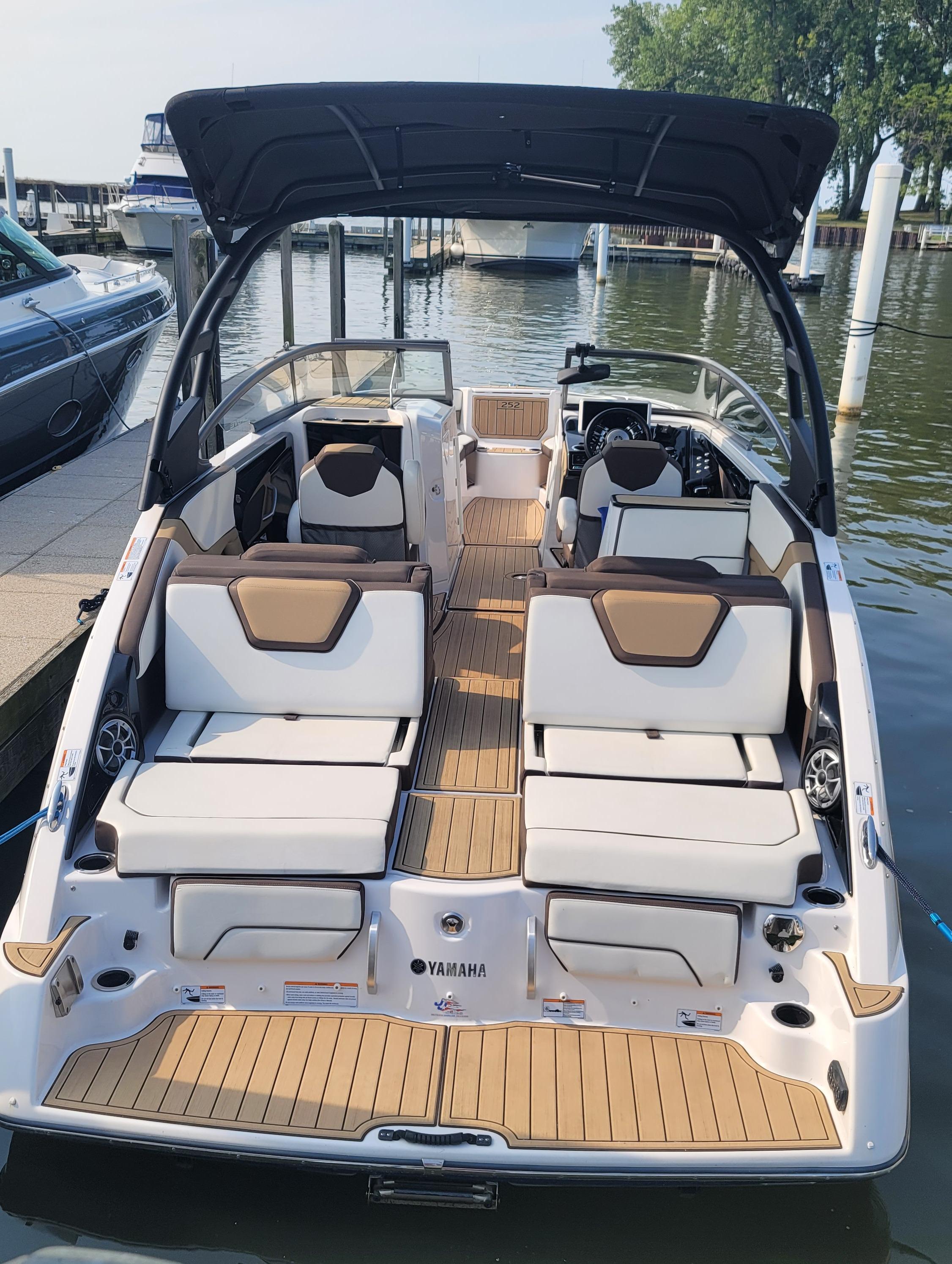 2021 Yamaha Boats 252SD, luxury interior, docked at marina, featuring spacious seating and modern design.