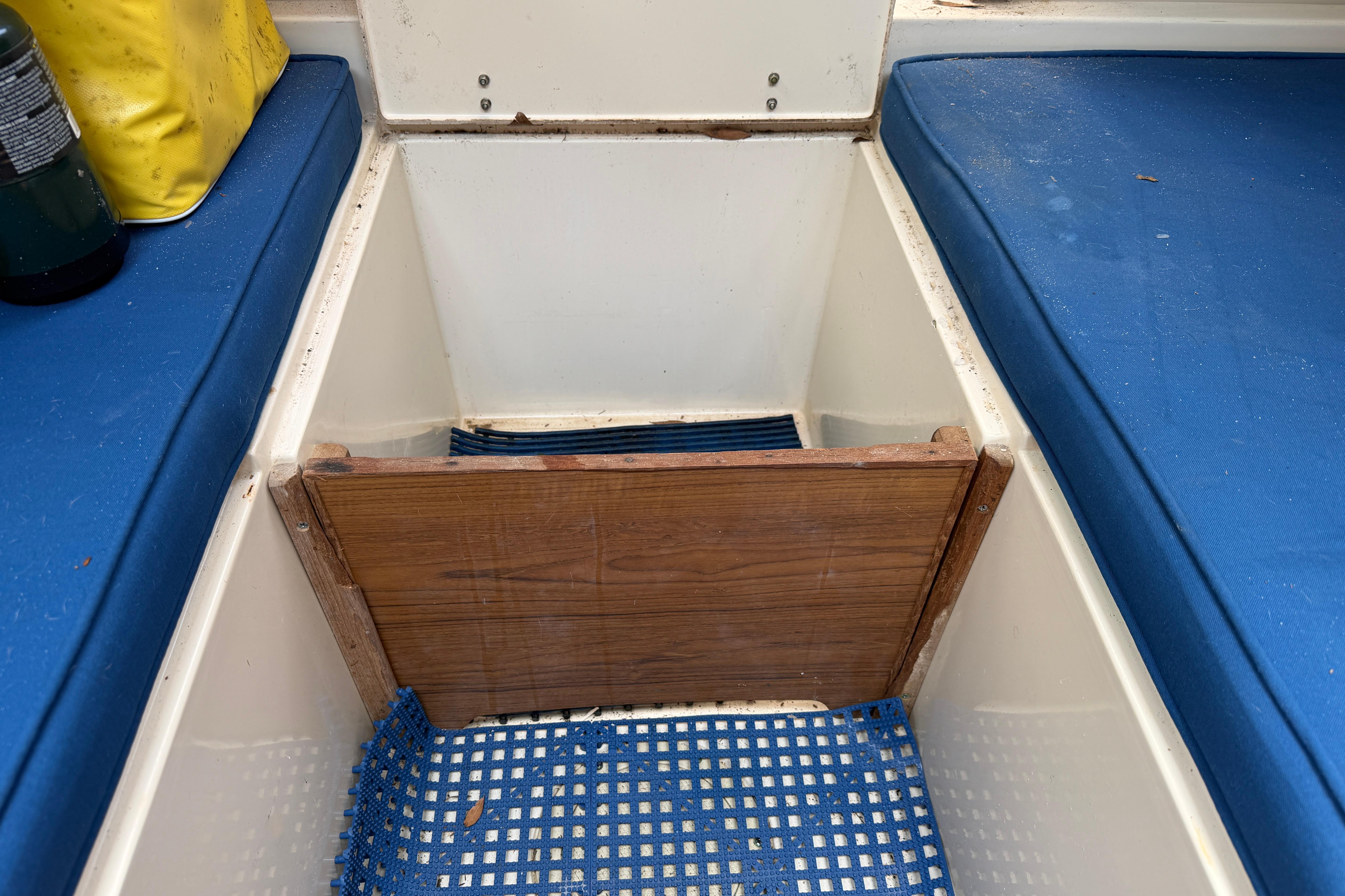 Interior of 1987 Grady-White Seafarer 226 boat with blue cushions and storage compartment.
