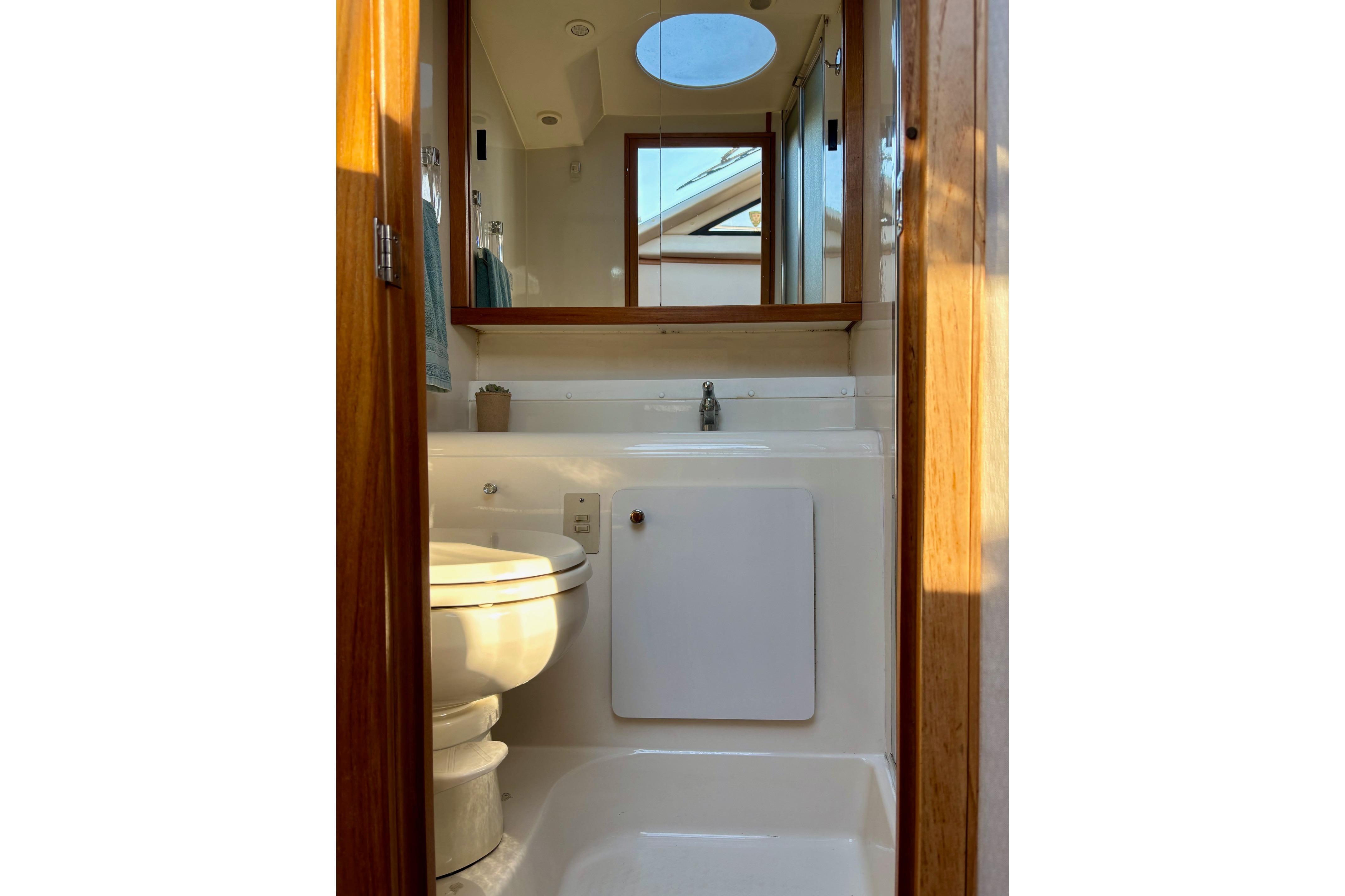 Bathroom interior of 1998 Bayliner 3388 Command Bridge Motoryacht, featuring toilet and sink.