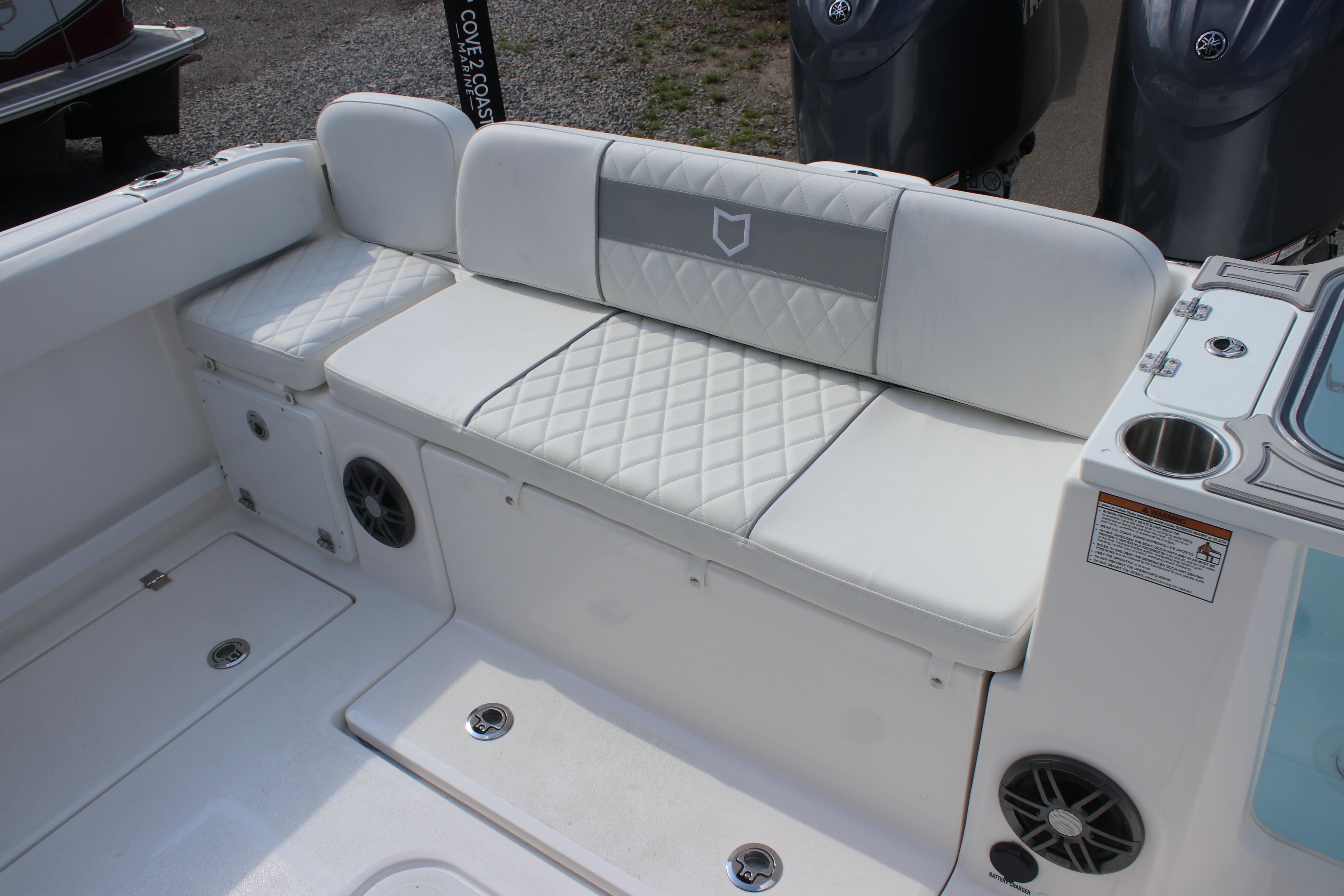 2026 Sea Fox 268 Commander boat interior with white cushioned seating and storage compartments.