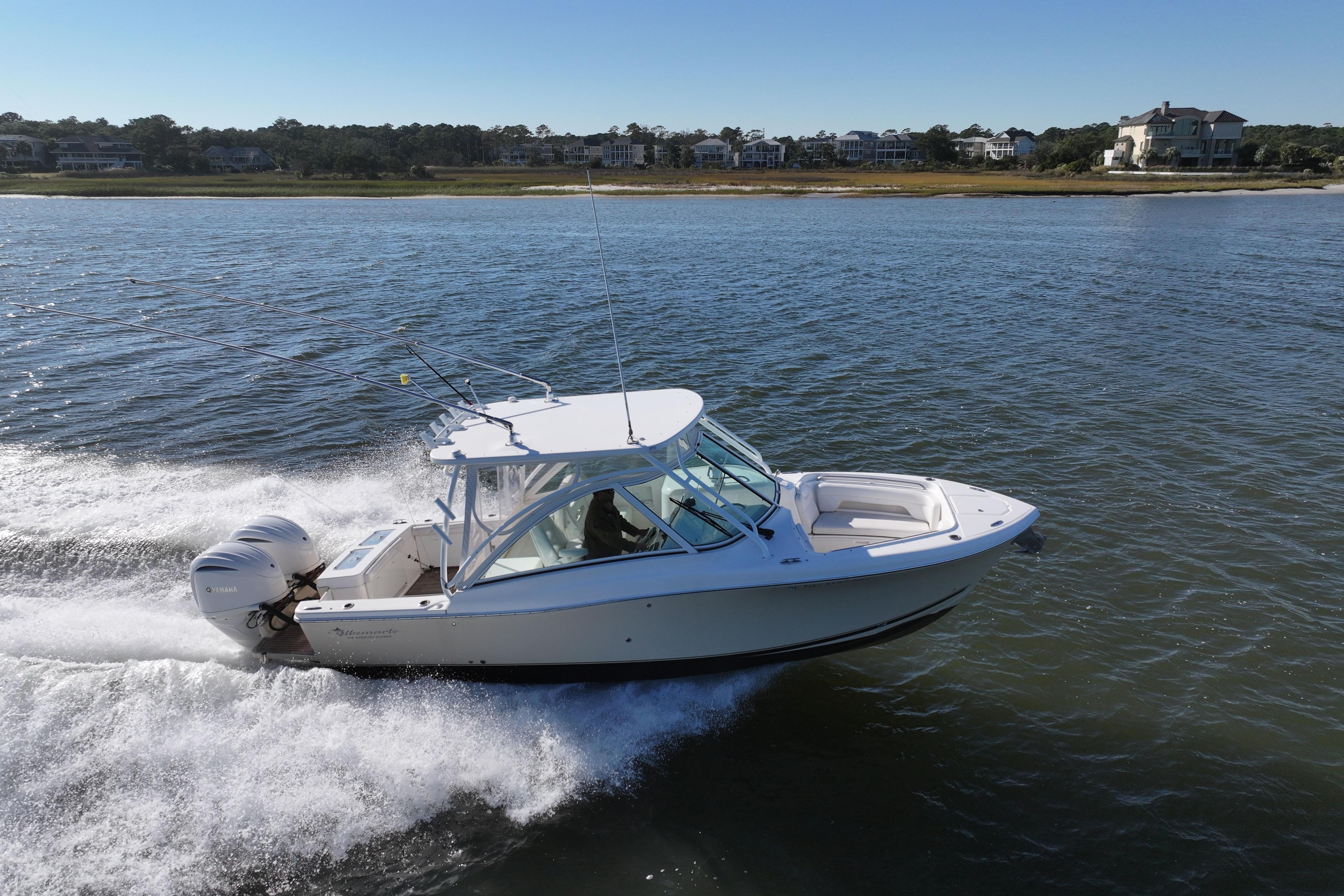 2022 Albemarle 27 DC boat cruising on a sunny day near the shoreline.