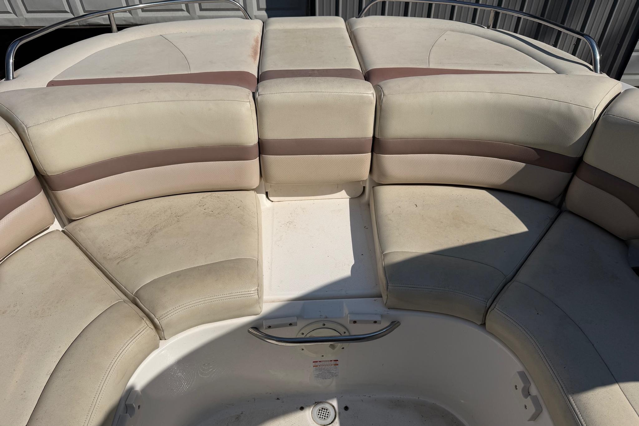 2005 Chaparral 256 SSi boat interior with beige seating and stainless steel railings.