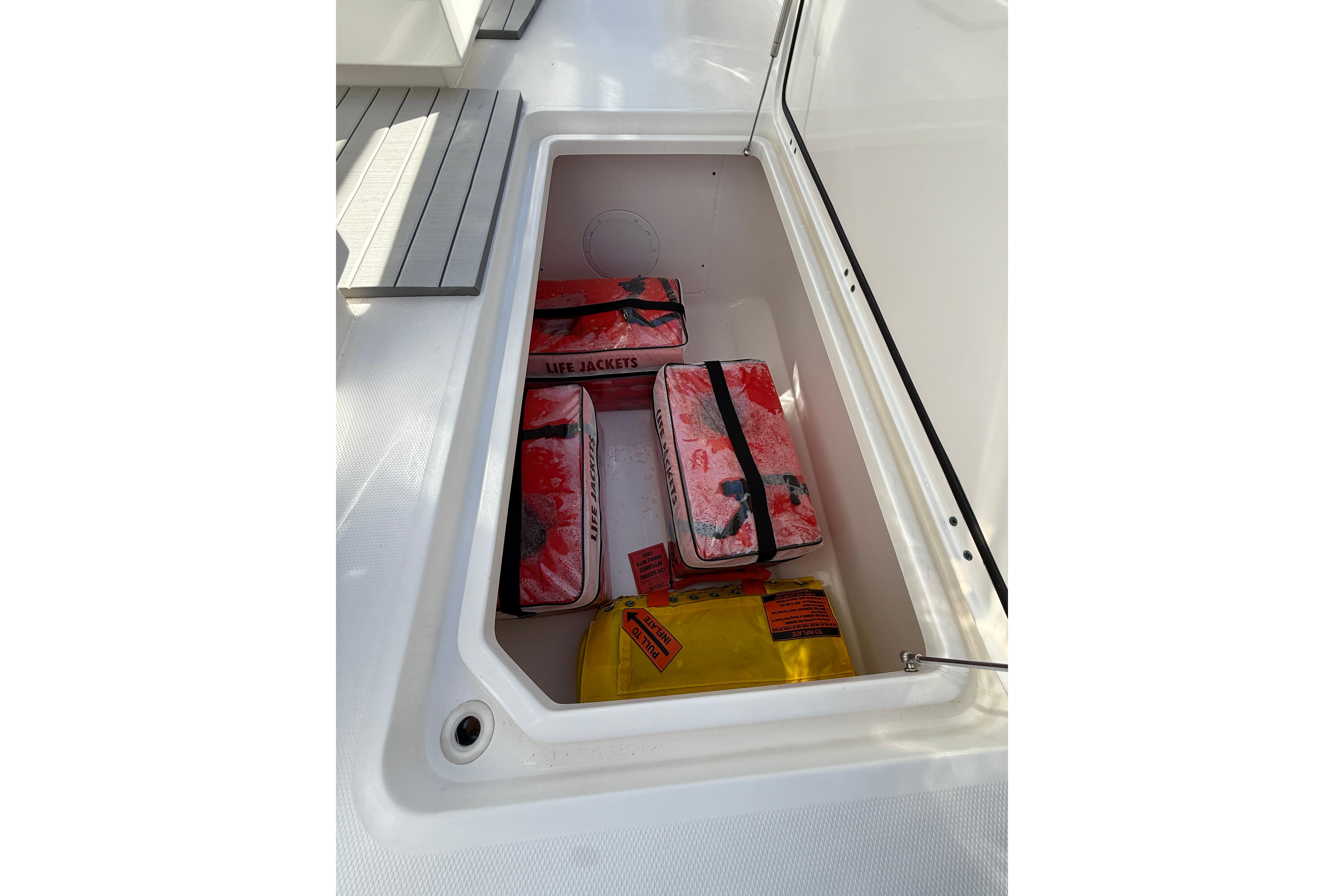 Storage compartment on 2022 Invincible 40 Catamaran with life jackets and safety equipment.