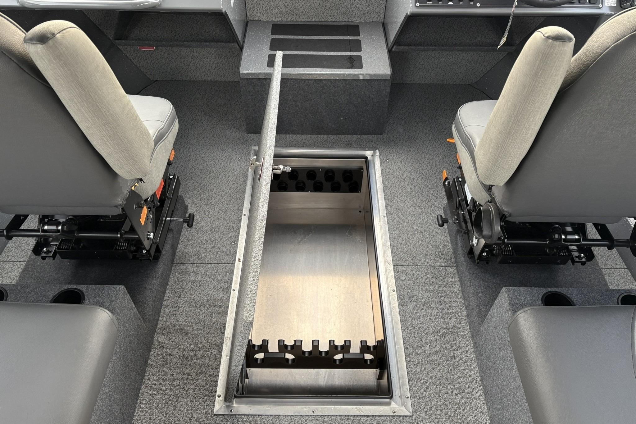 2024 Spartan 26 Maximus Pro XL interior with open storage compartment between seats.