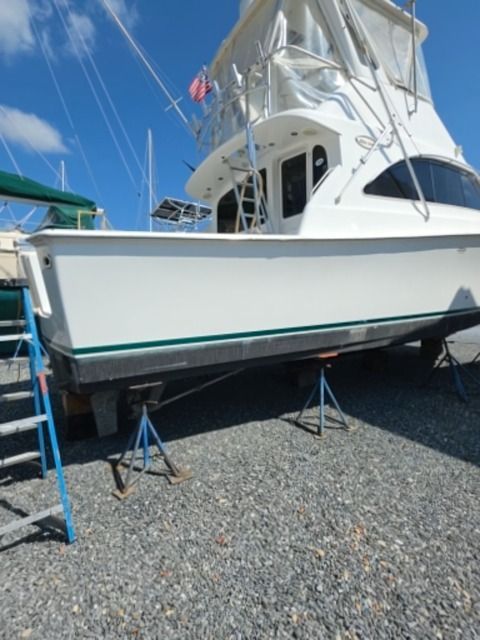 1998 Ocean Yachts SS40 on stands in gravel lot, side view.