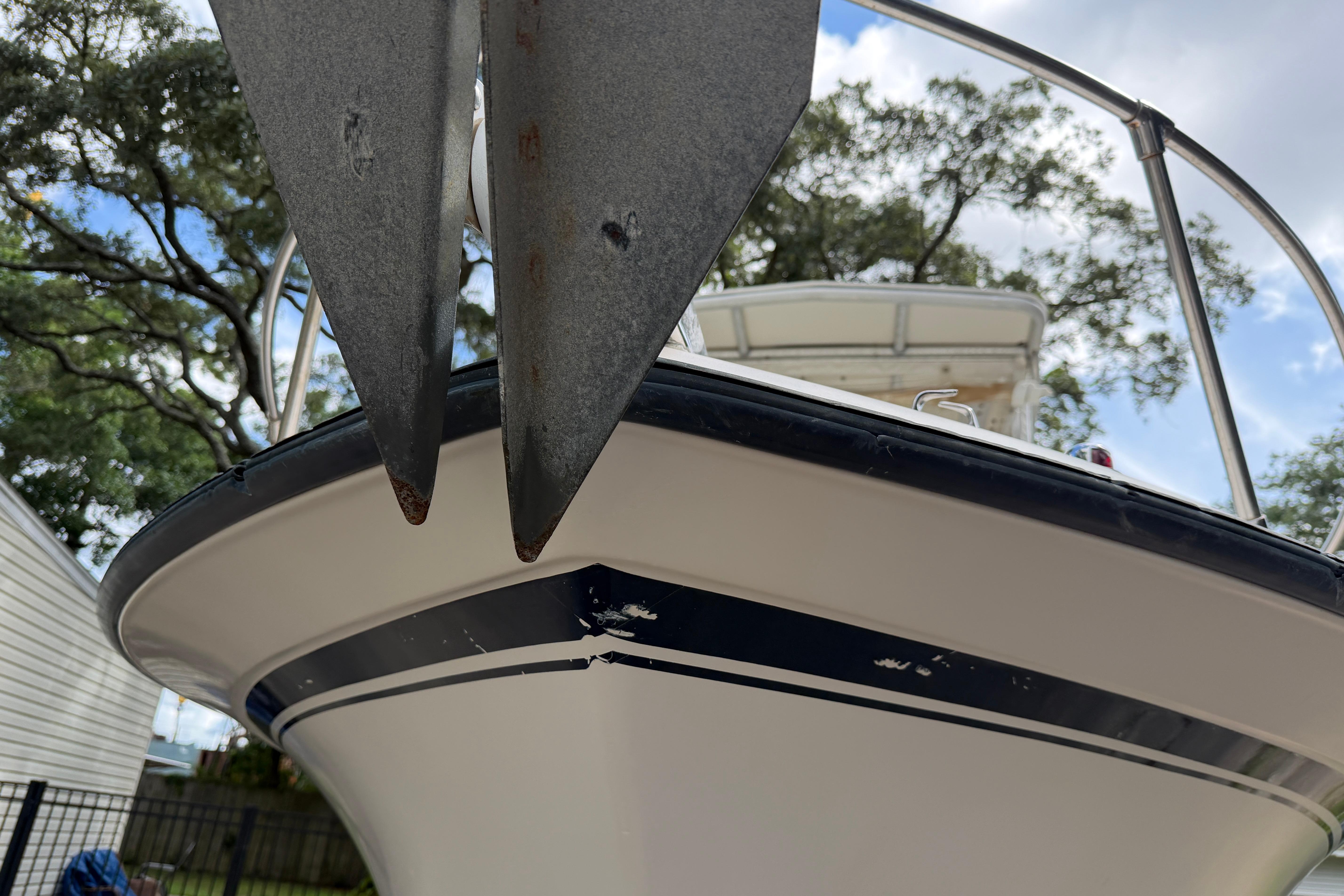 1987 Grady-White Seafarer 226 boat with anchor, viewed from below, against a tree-lined background.