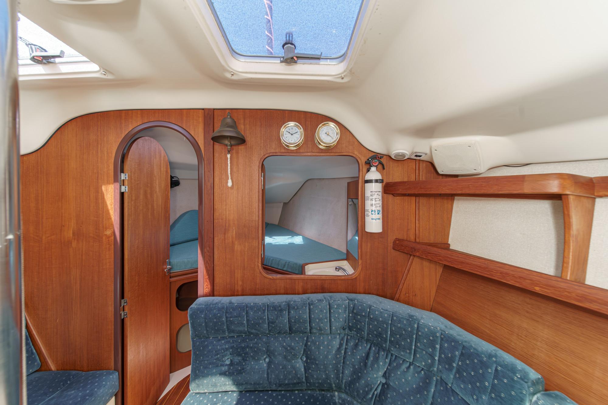 Interior of a 1996 Hunter 376 sailboat with wood paneling and blue seating.