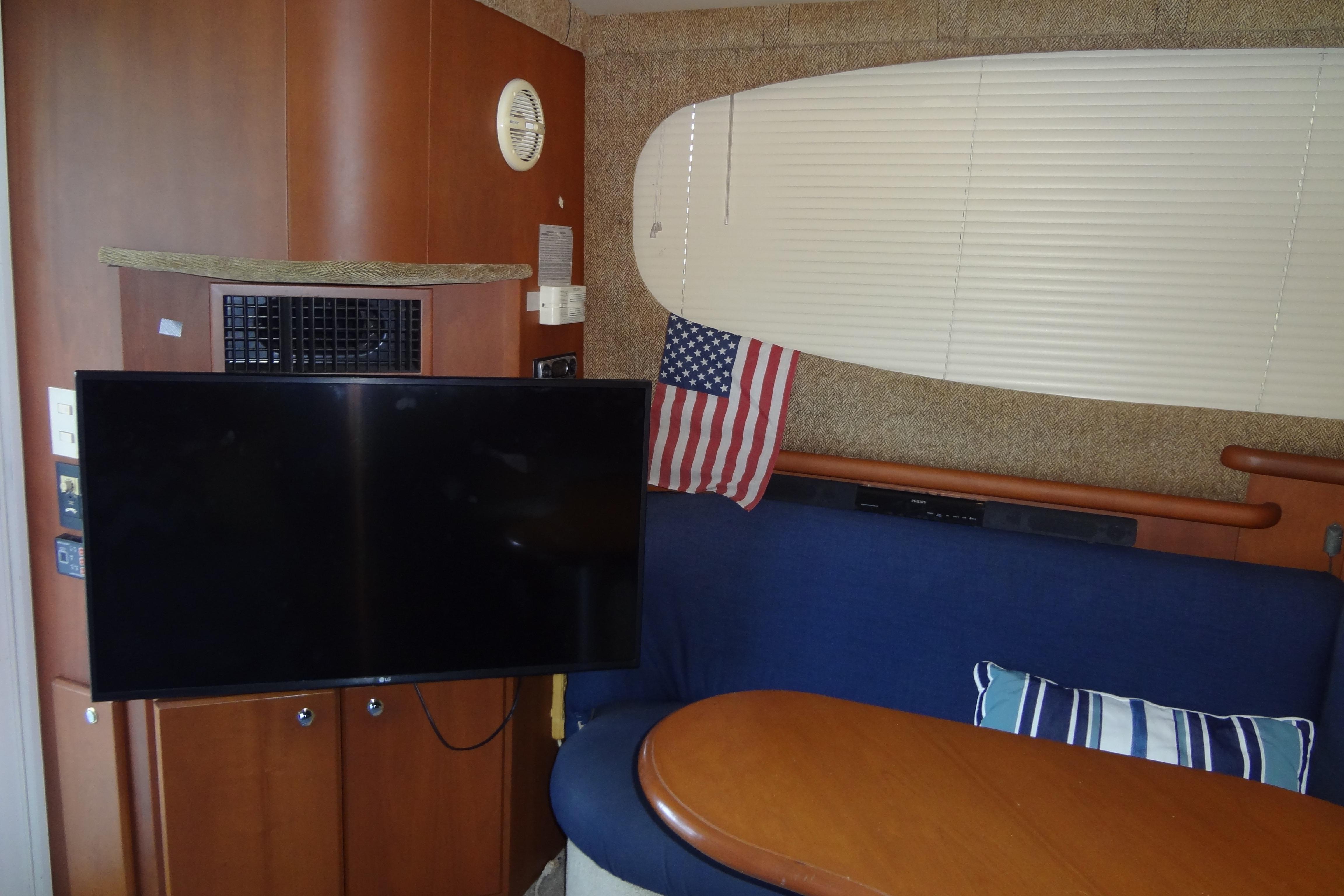 Interior of 2005 Silverton 34 Convertible yacht with TV, American flag, and seating area.