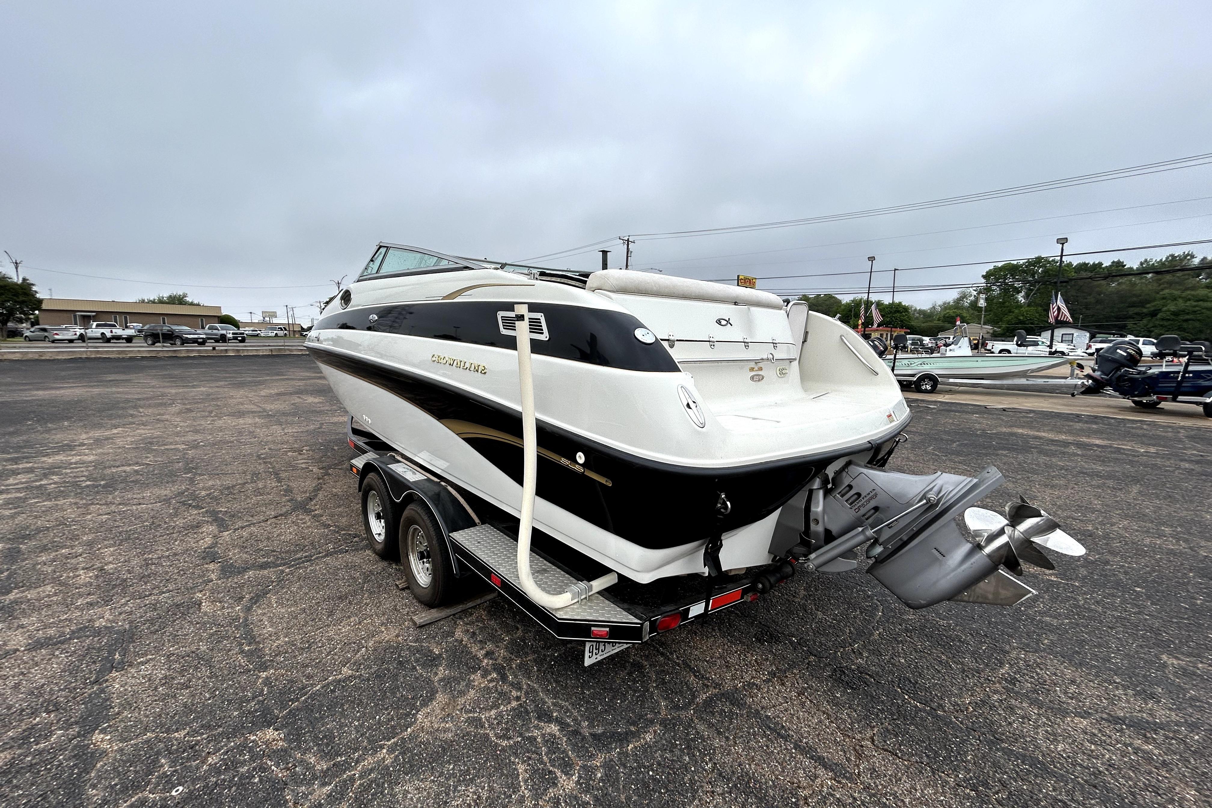 2001 Crownline 239 DB boat on trailer, parked in a lot under cloudy skies.