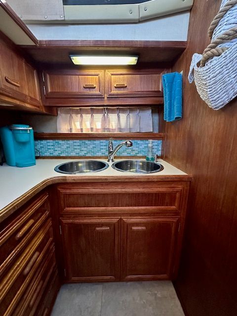 1988 Carver 3807 Aft Cabin Yacht kitchen with double sink and wood cabinetry.