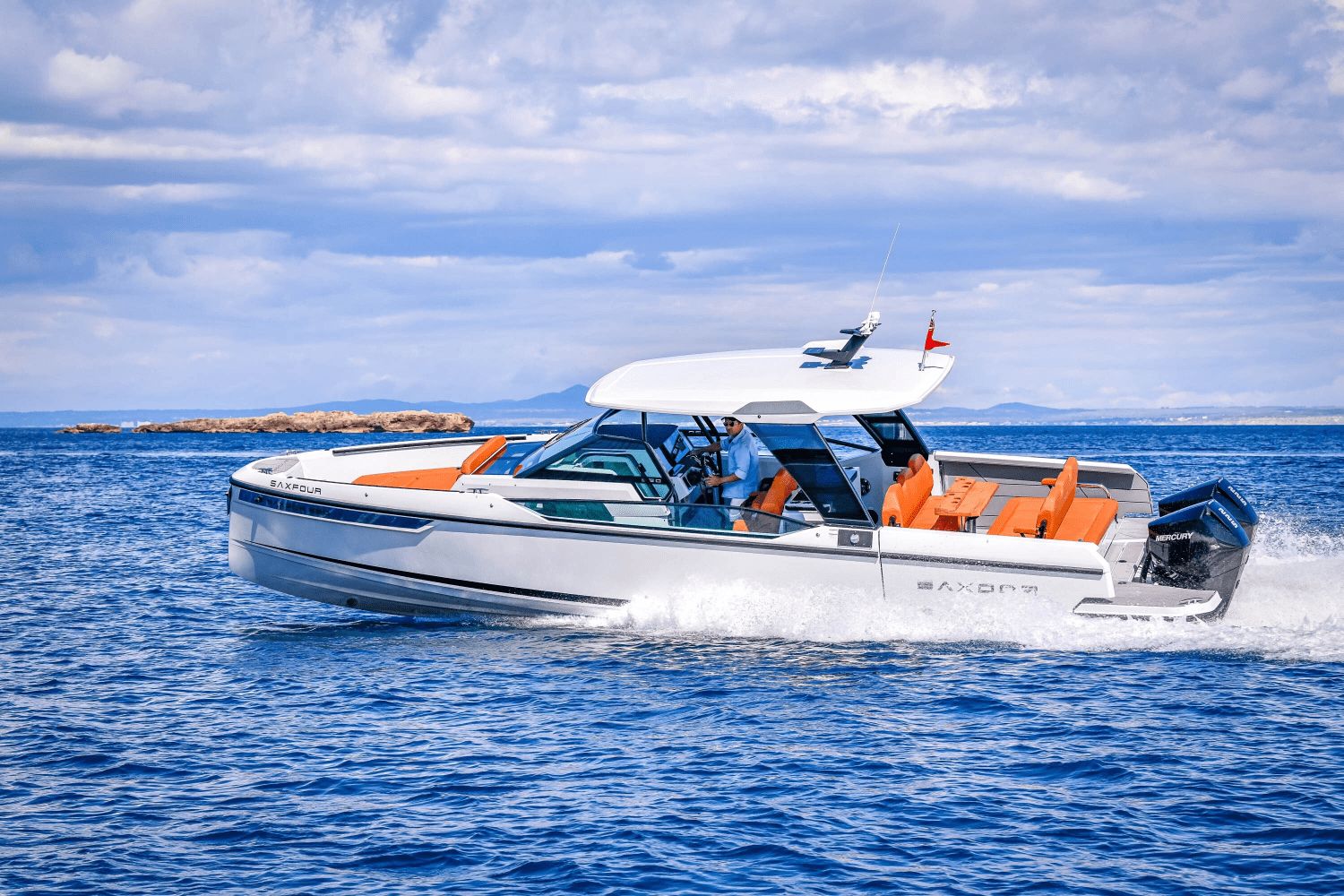 A modern motorboat with orange seats cruising on the sea.
