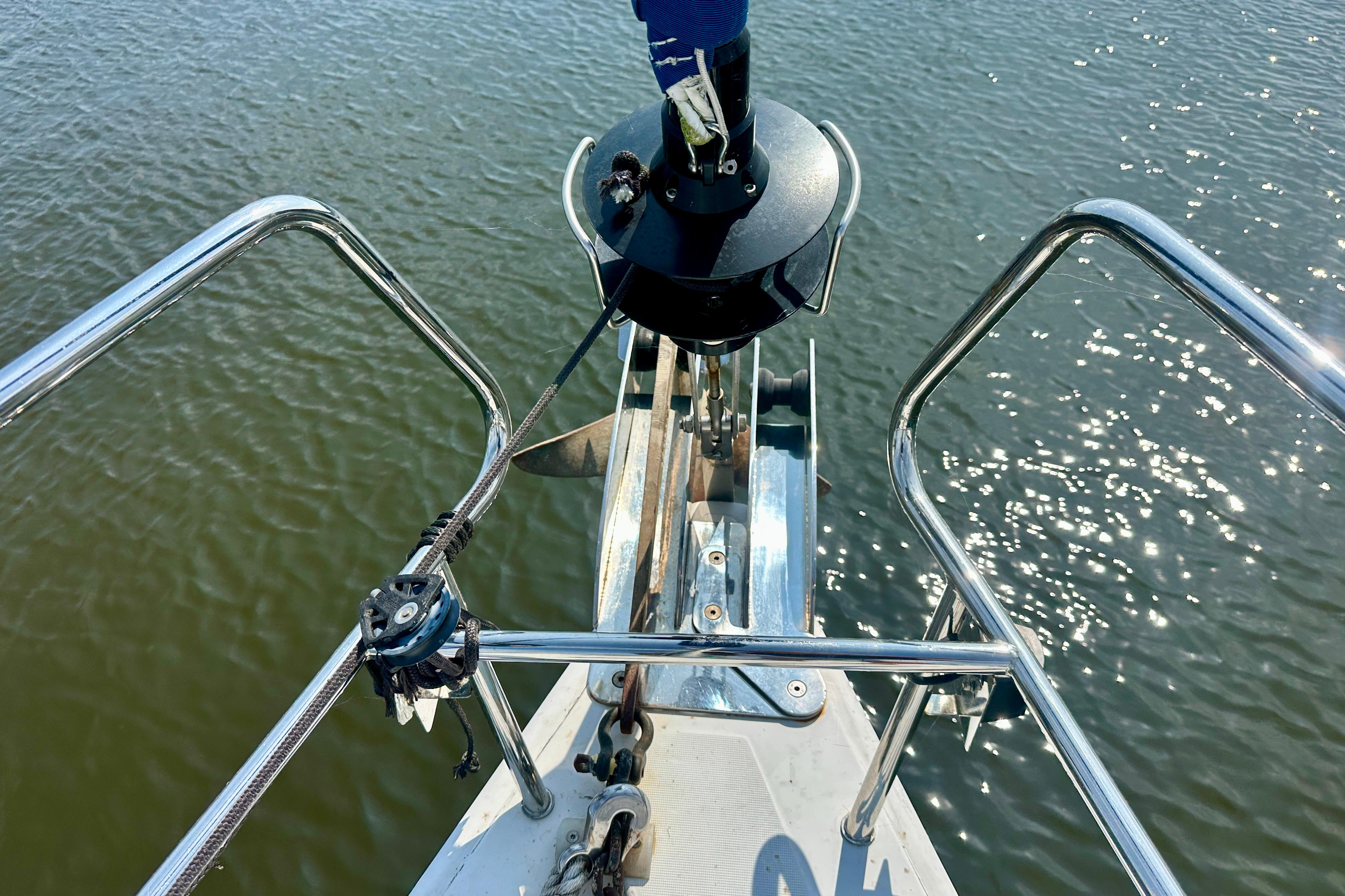 Bow of 2010 Beneteau Oceanis 40 sailboat with anchor over water.