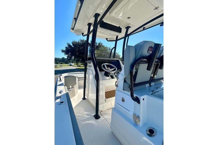 2026 Ranger 2360 Bay boat interior with steering console and seating, under clear blue sky.