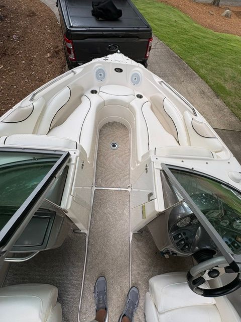 Interior view of a 2007 Rinker 226 Captiva Bowrider with white seating and gray carpet.