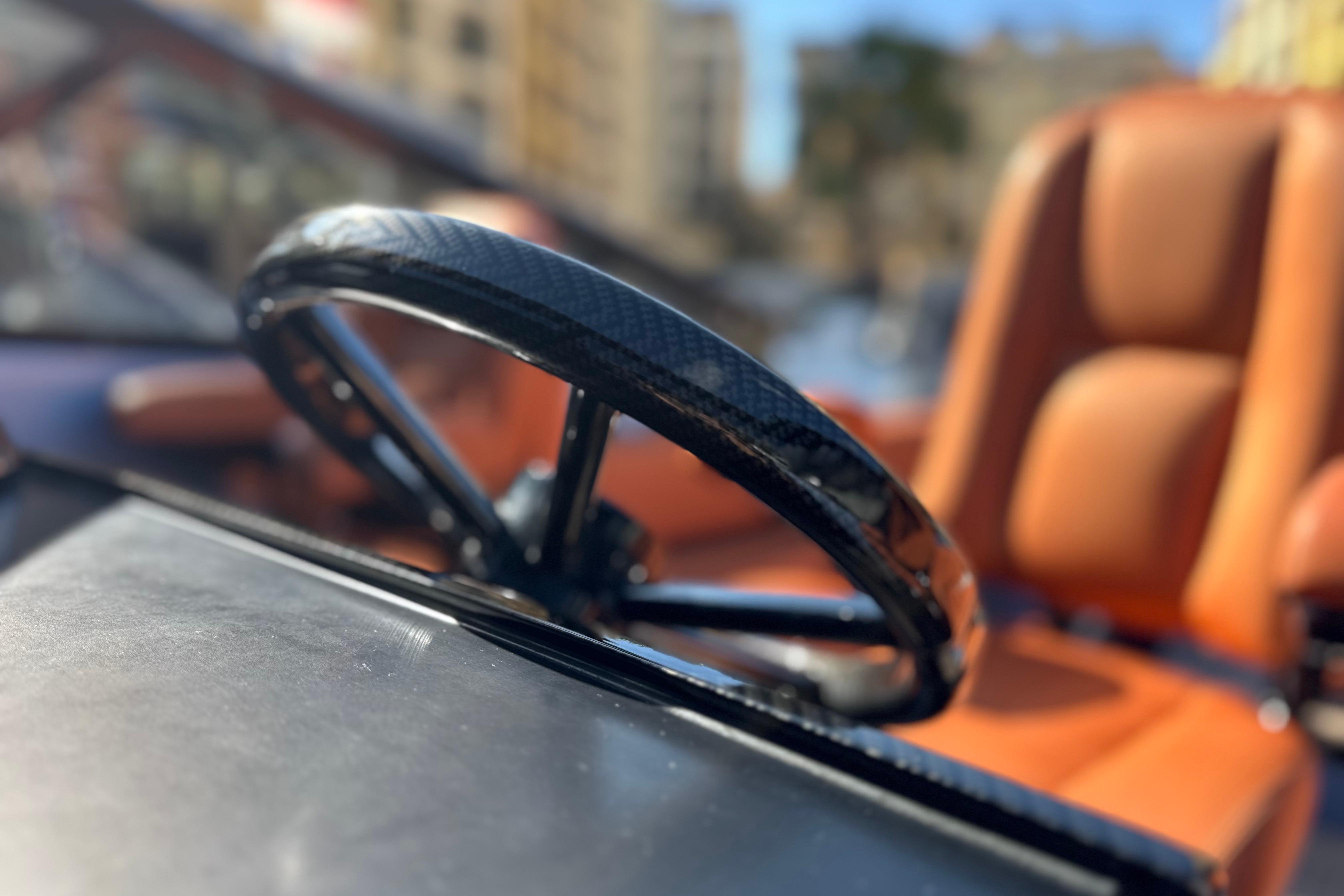 Steering wheel of a 2014 Wajer 38 boat with leather seats in the background.